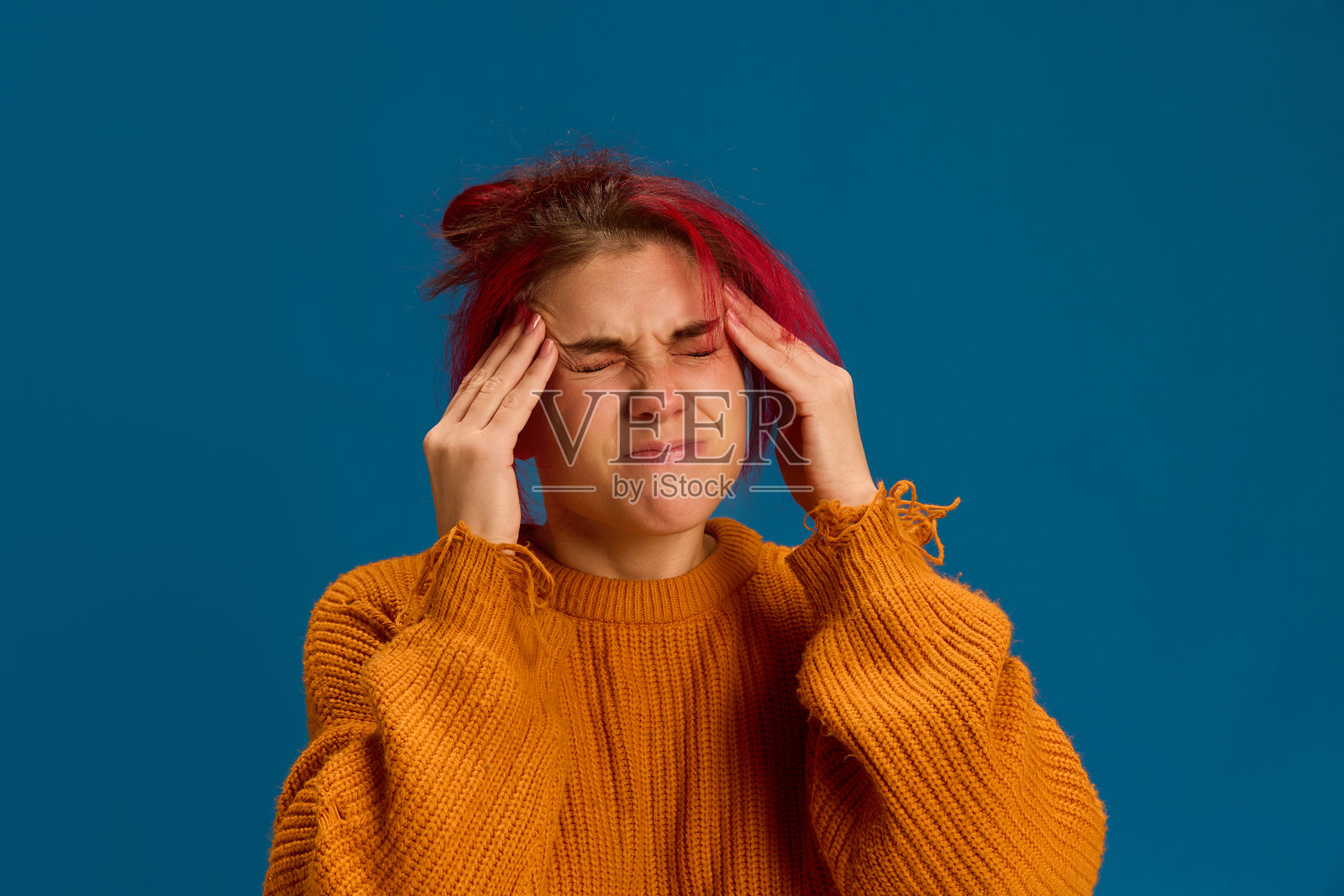 女性因剧烈头痛而按压太阳穴以缓解疼痛。与偏头痛或病毒感染有关。照片摄影图片