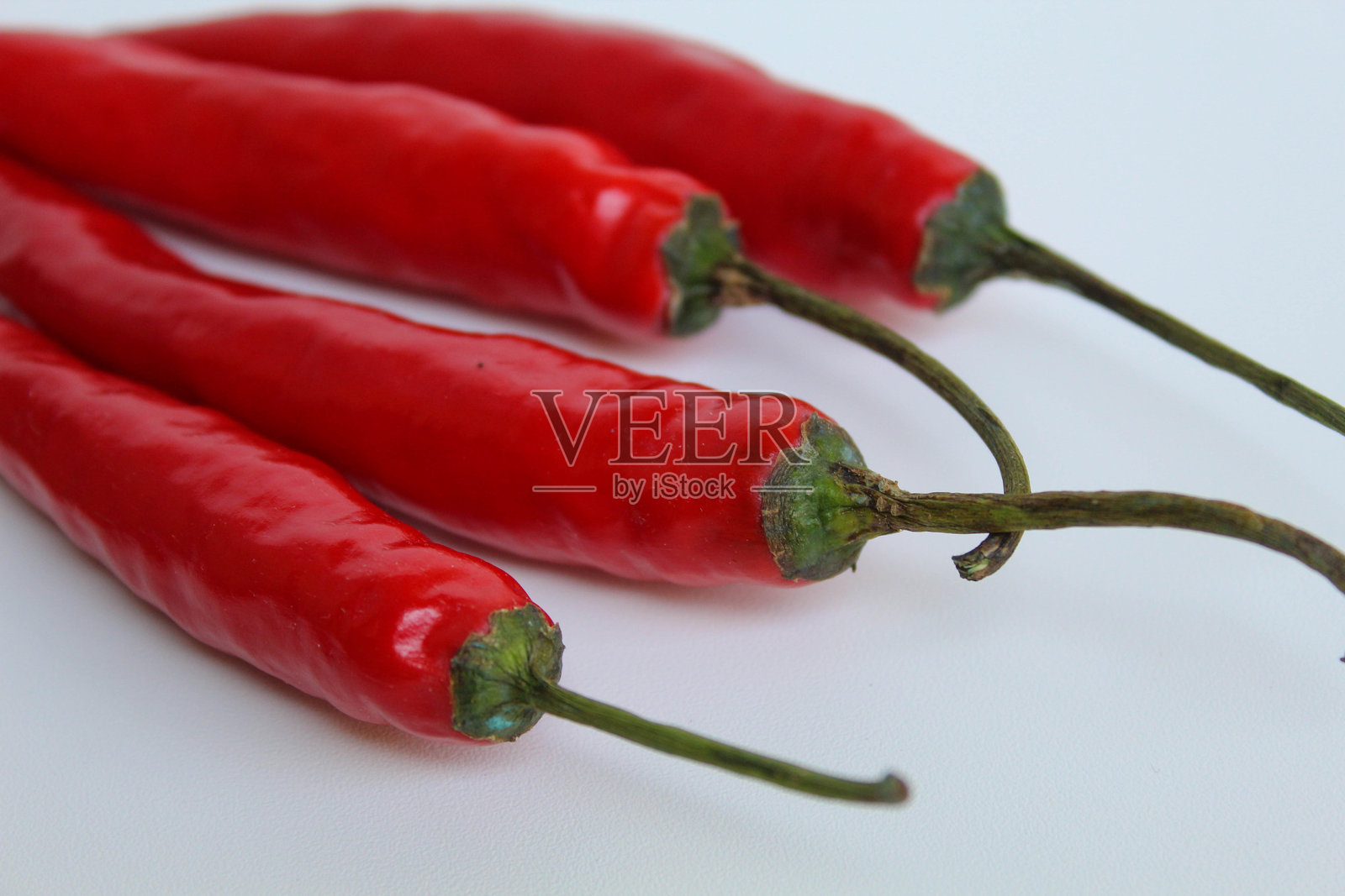 新鲜的大红辣椒,带有绿色茎,孤立在白色背景上照片摄影图片