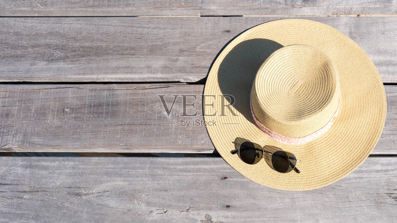 在温暖的下午,戴着太阳帽和太阳镜在科穆诺克岛放松。照片摄影图片