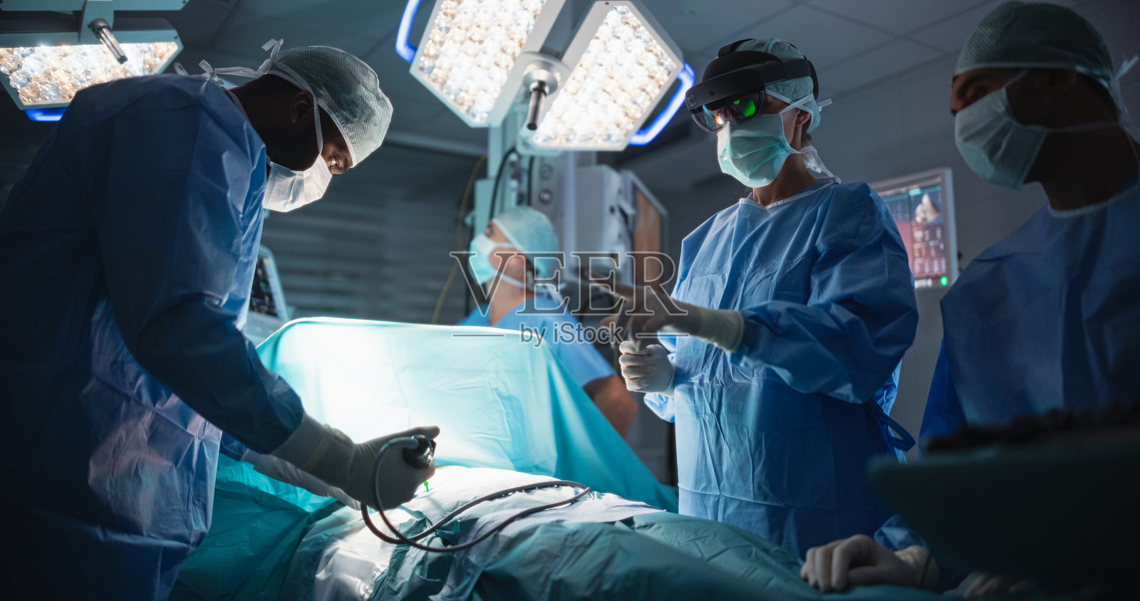 在手术室进行侵入性医疗手术时,女外科医生通过未来派增强现实眼镜访问个人患者数据。先进技术为她的团队提供手术指导。照片摄影图片