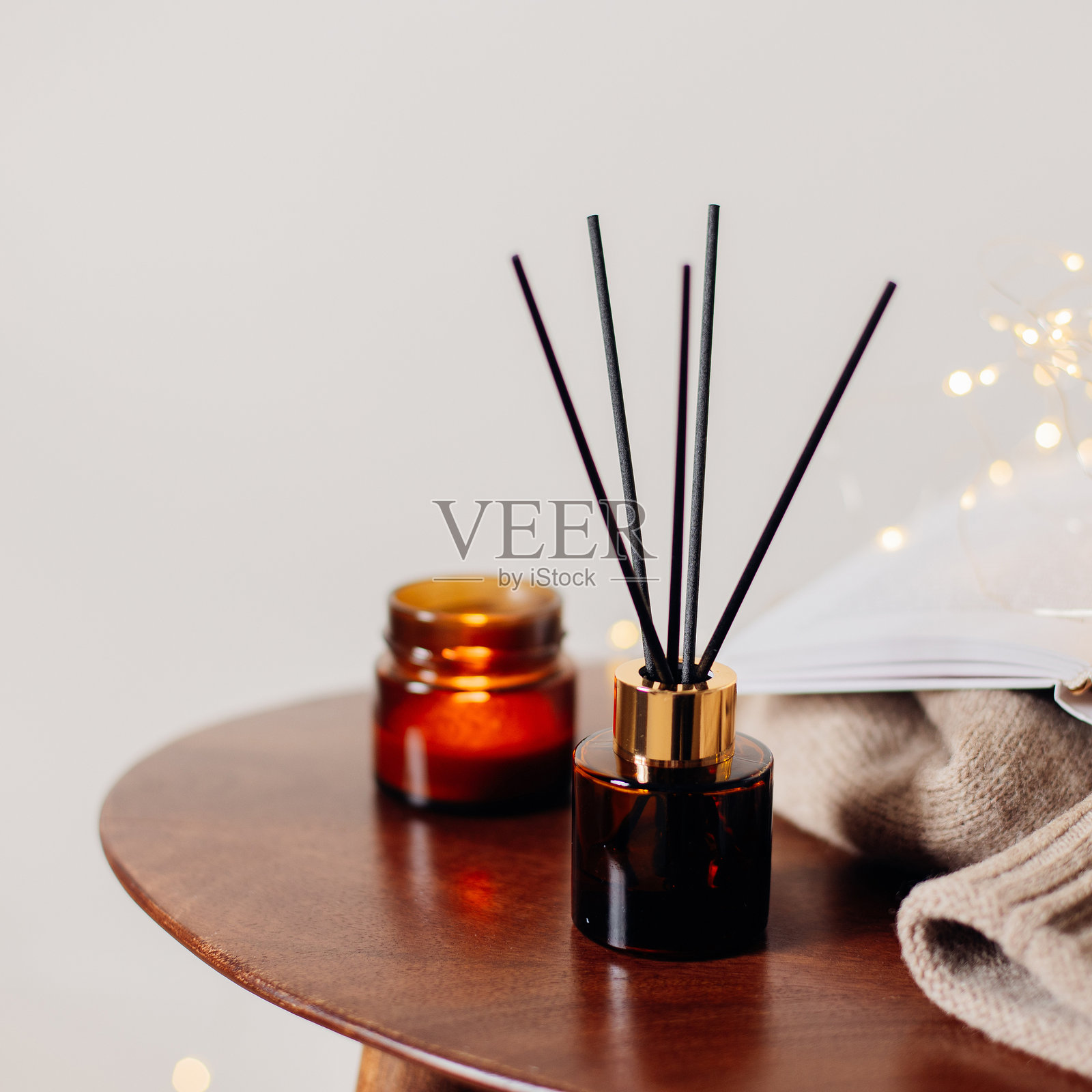 卧室木桌上的家用香氛扩散器和燃烧的蜡烛。室内元素。留白空间照片摄影图片