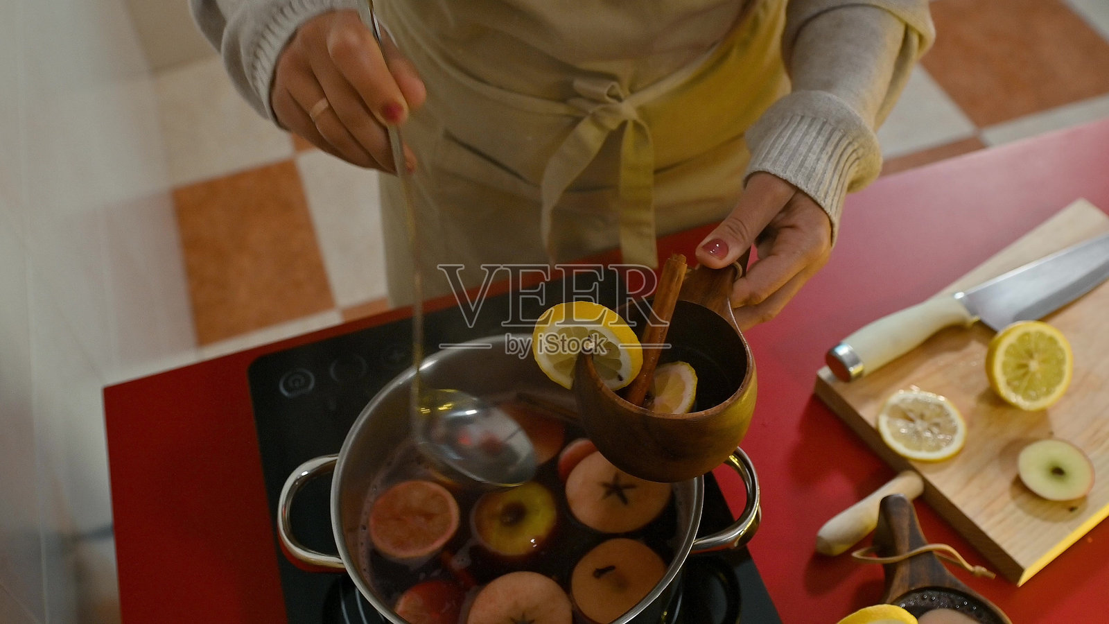 在温馨的厨房环境中准备水果和香料的热红酒照片摄影图片