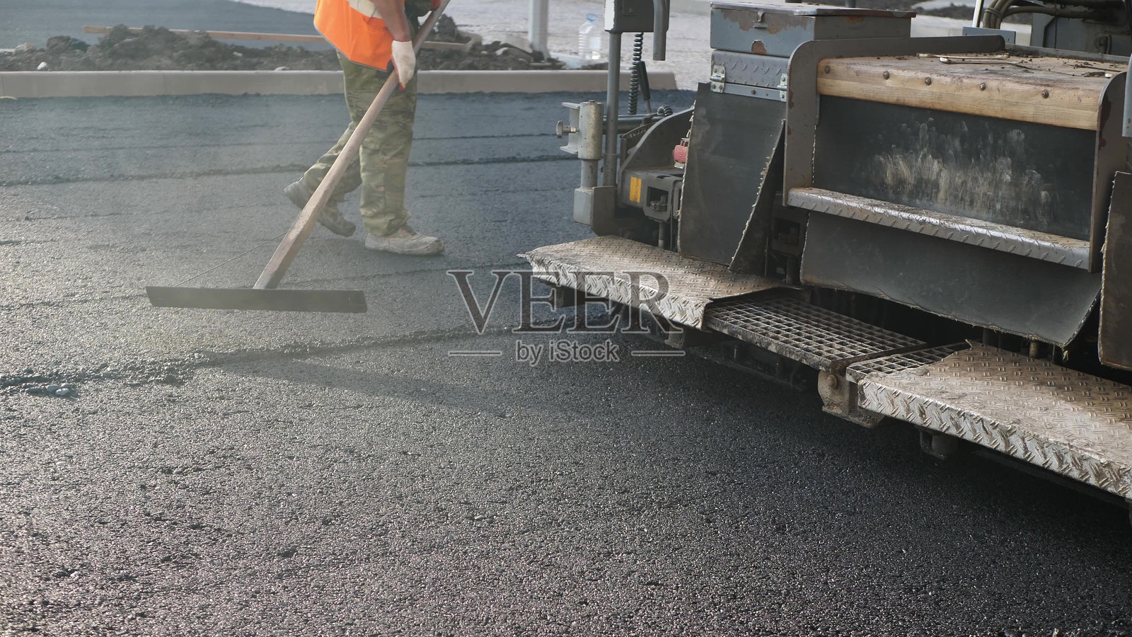 公路施工现场的沥青摊铺机或沥青铺路机。道路修复。照片摄影图片