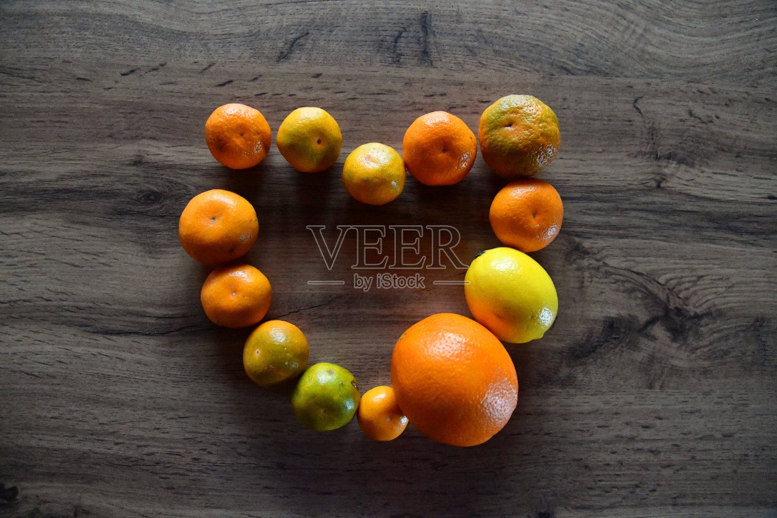 在桌子上平衡柑橘类水果。柑橘类水果金字塔:葡萄柚、青柠、橙子、柠檬放在橙子上。照片摄影图片