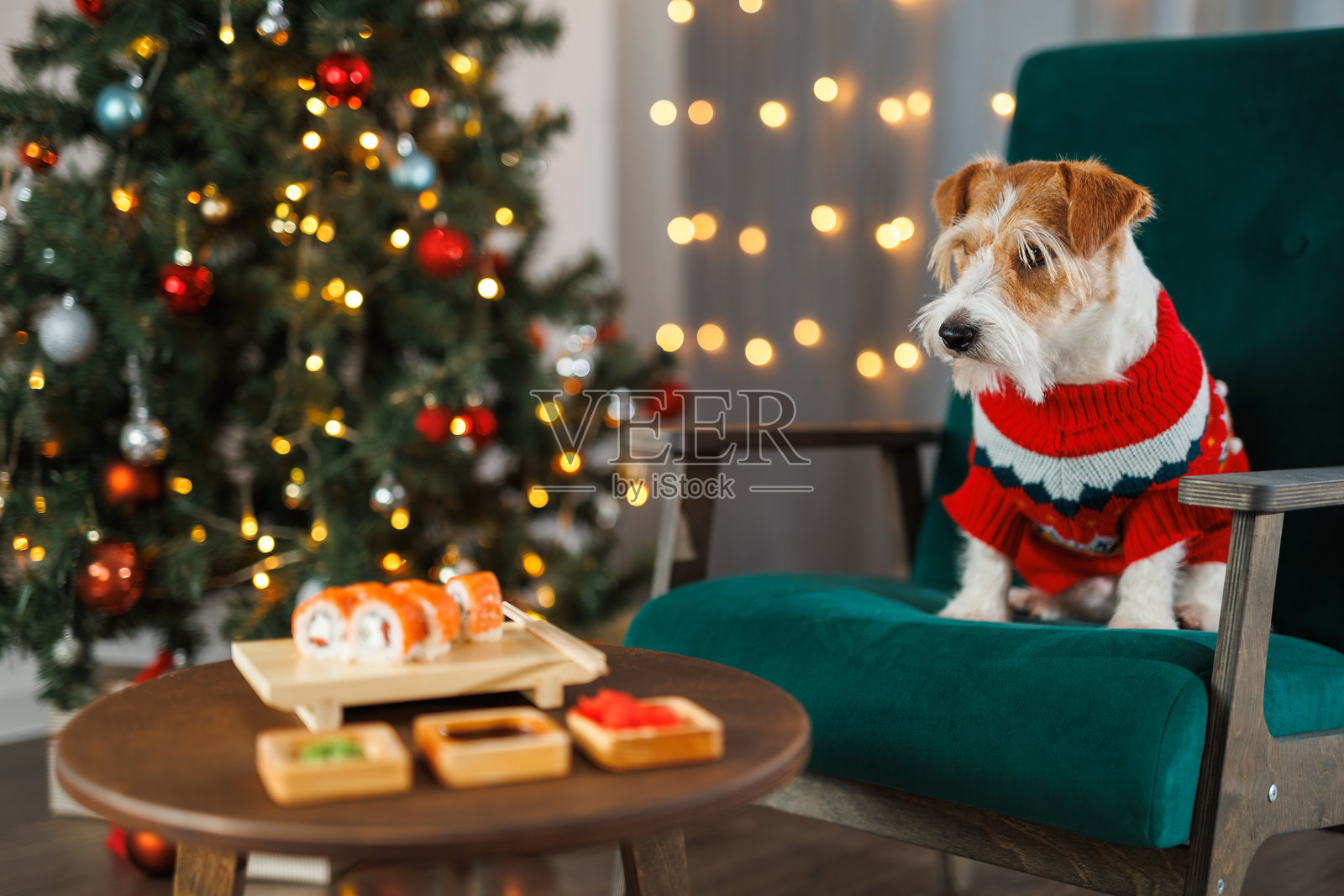 一辆现代露营车配备太阳能板,停靠在宁静的湖边,四周被绿色森林和远处的山脉环绕,天空湛蓝。附近搭建了篝火和椅子。照片摄影图片