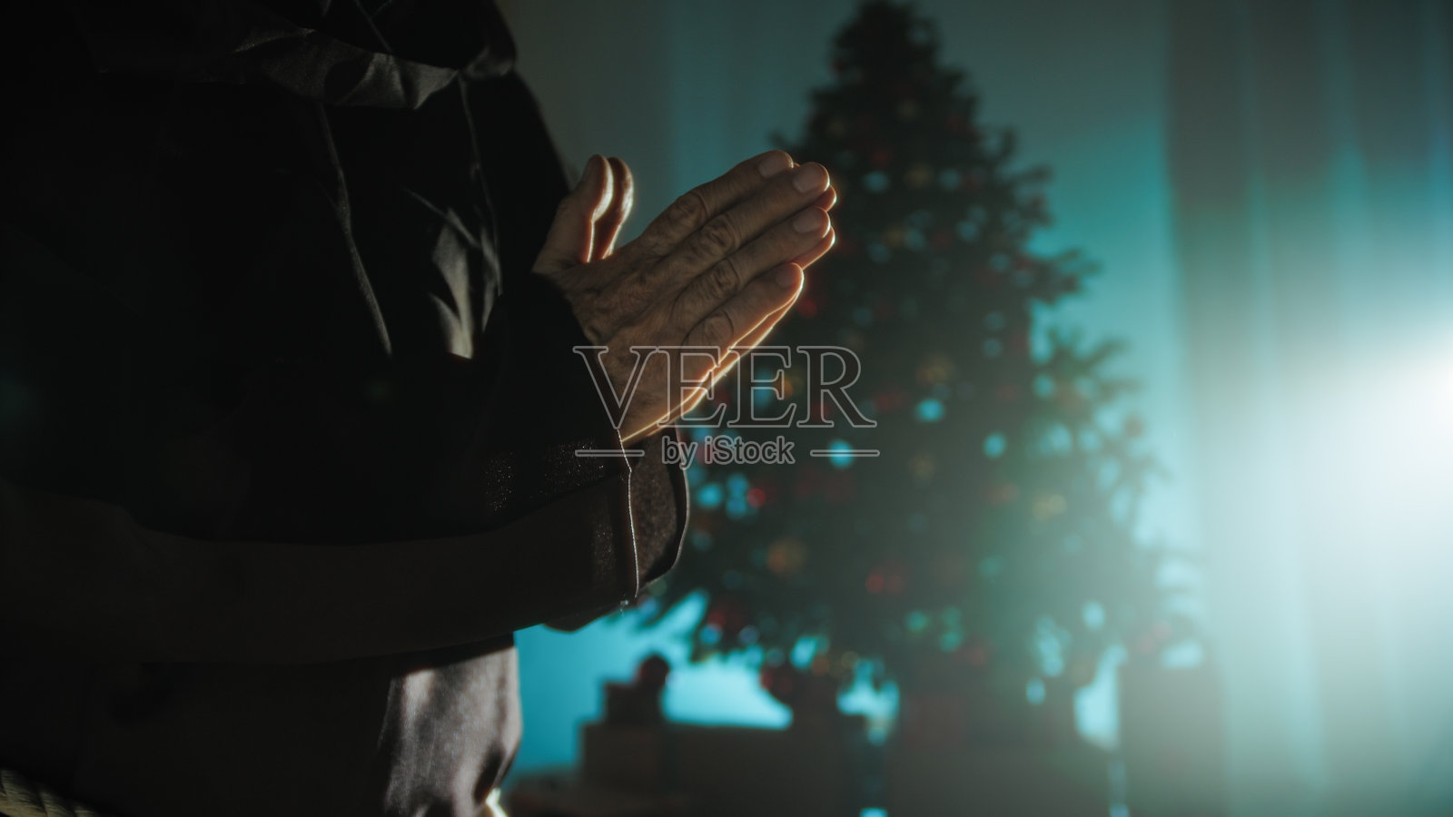 基督教宗教祈祷手的剪影在圣诞树前照片摄影图片