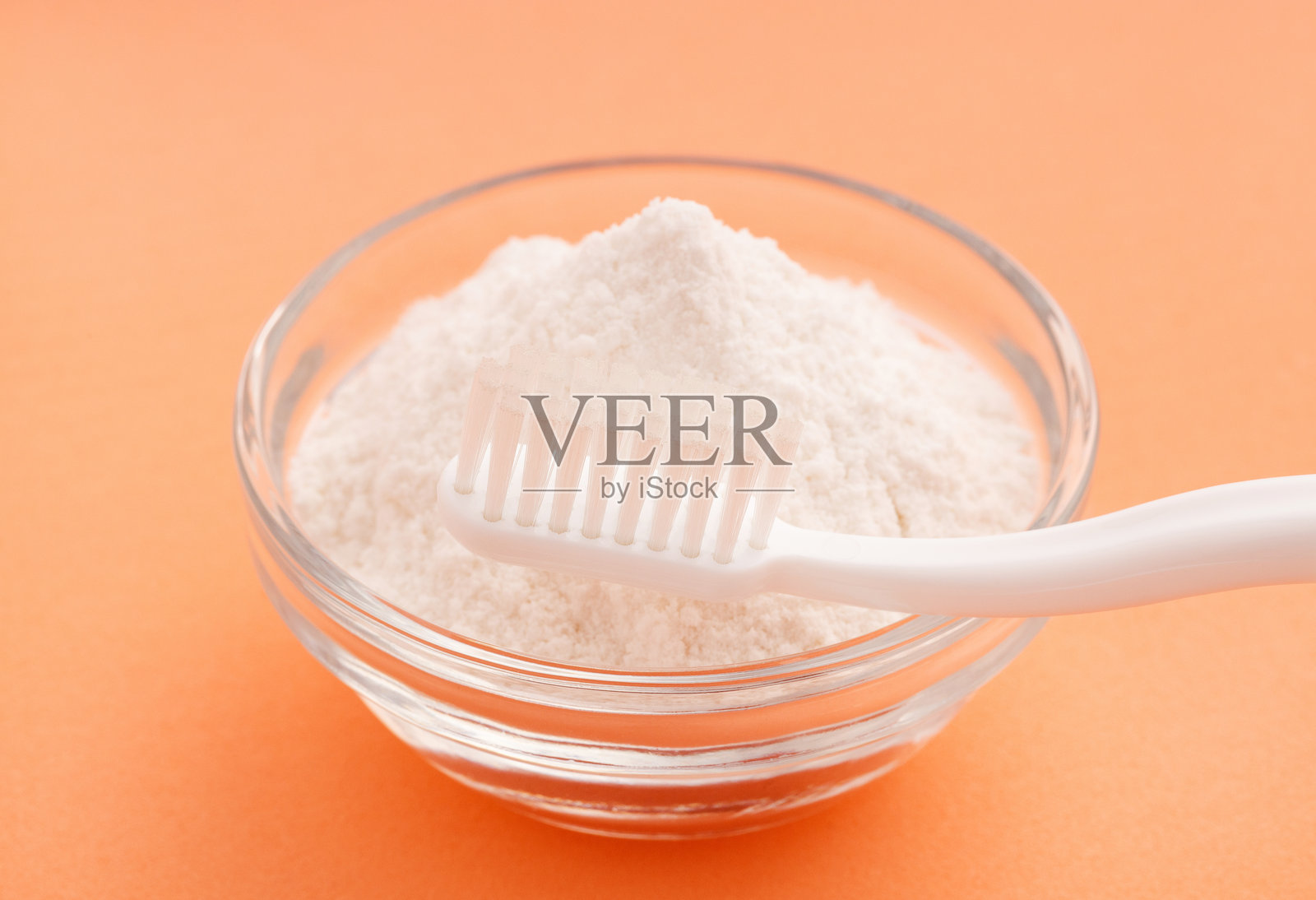 碗中的牙刷和小苏打 - 粉色背景。照片摄影图片