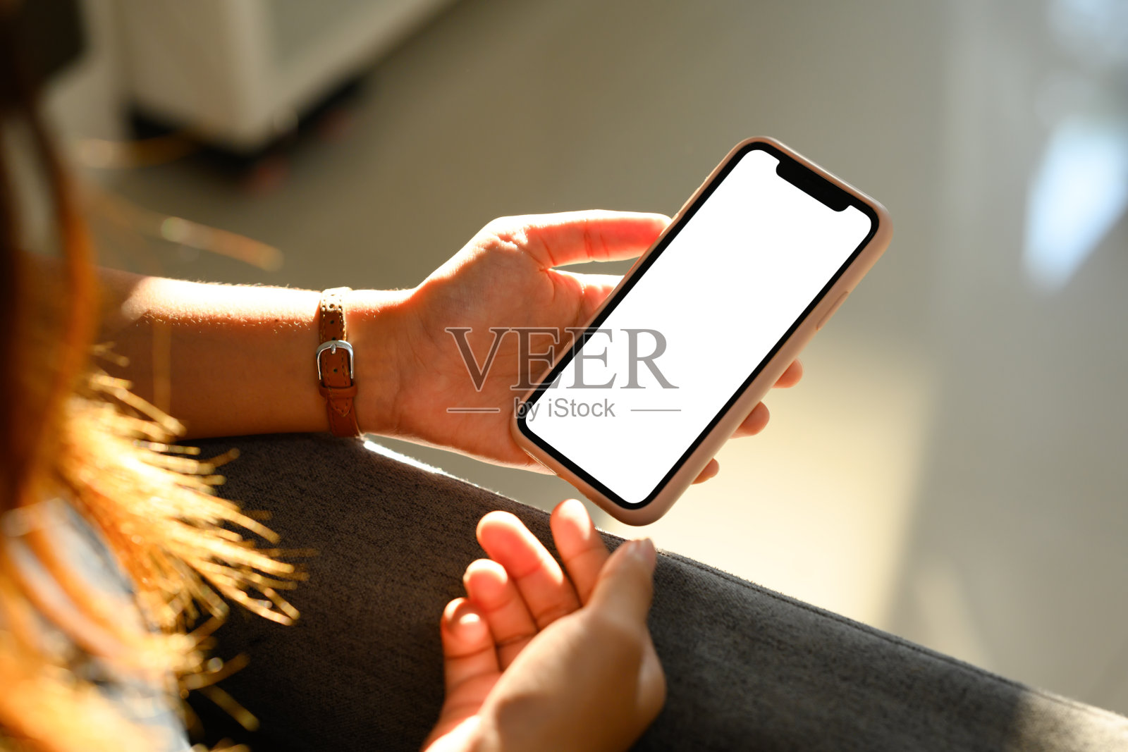 阳光下手握空屏智能手机的特写镜头照片摄影图片