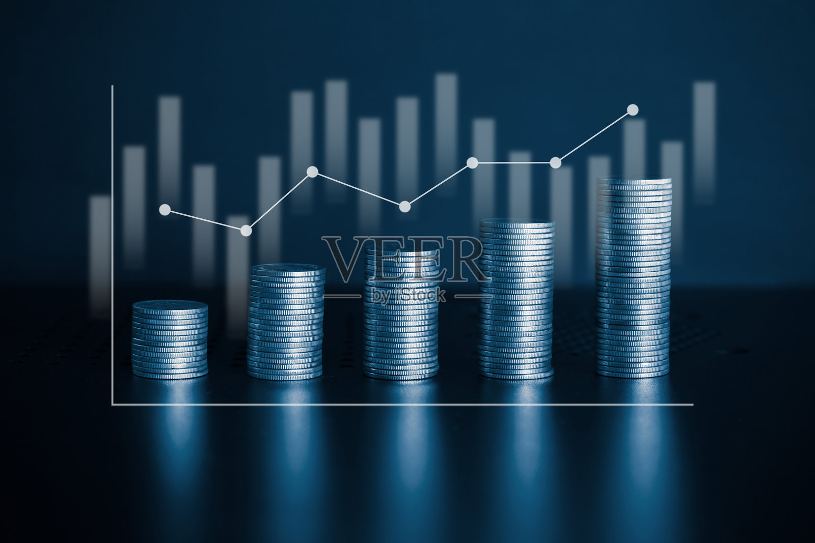 钱币堆叠与带蓝色滤镜的股票交易市场图表。金融背景概念。照片摄影图片