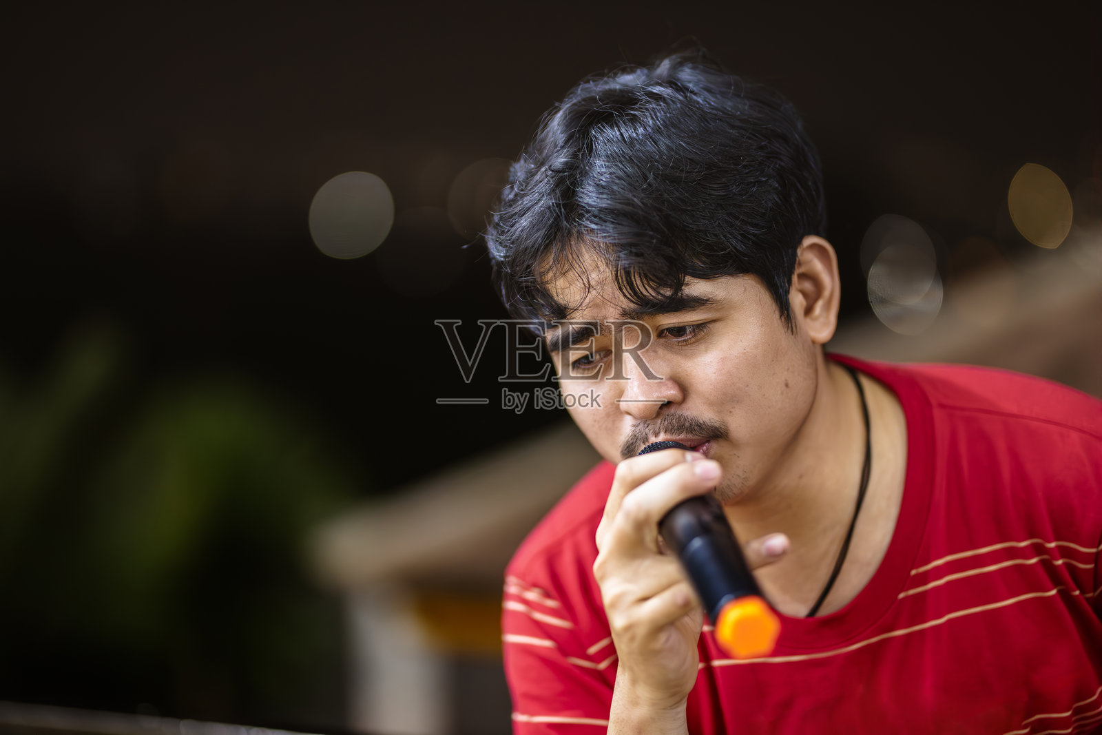 富有表现力的歌手与音乐互动。男歌手传达真挚的情感。照片摄影图片