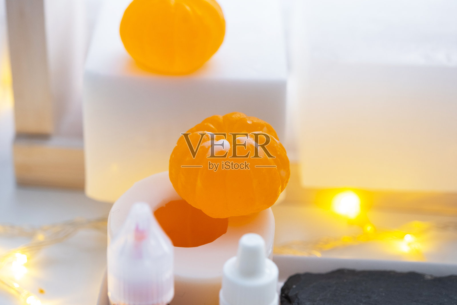 手工制作的橘子形状香皂,配有染料瓶、香料、甘油香皂基块、硅胶模具和吸管。作为礼物的自制香皂。照片摄影图片