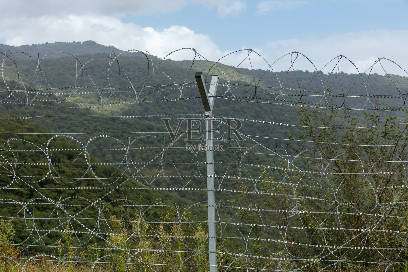 伊朗与阿塞拜疆之间的边界,带有铁丝网围栏和山脉风景照片摄影图片