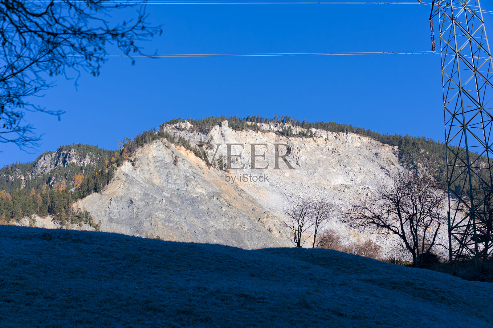 瑞士阿尔卑斯山脉中布伦扎乌斯村上方的山体滑坡,背景是阳光明媚的秋日蓝天。照片摄影图片