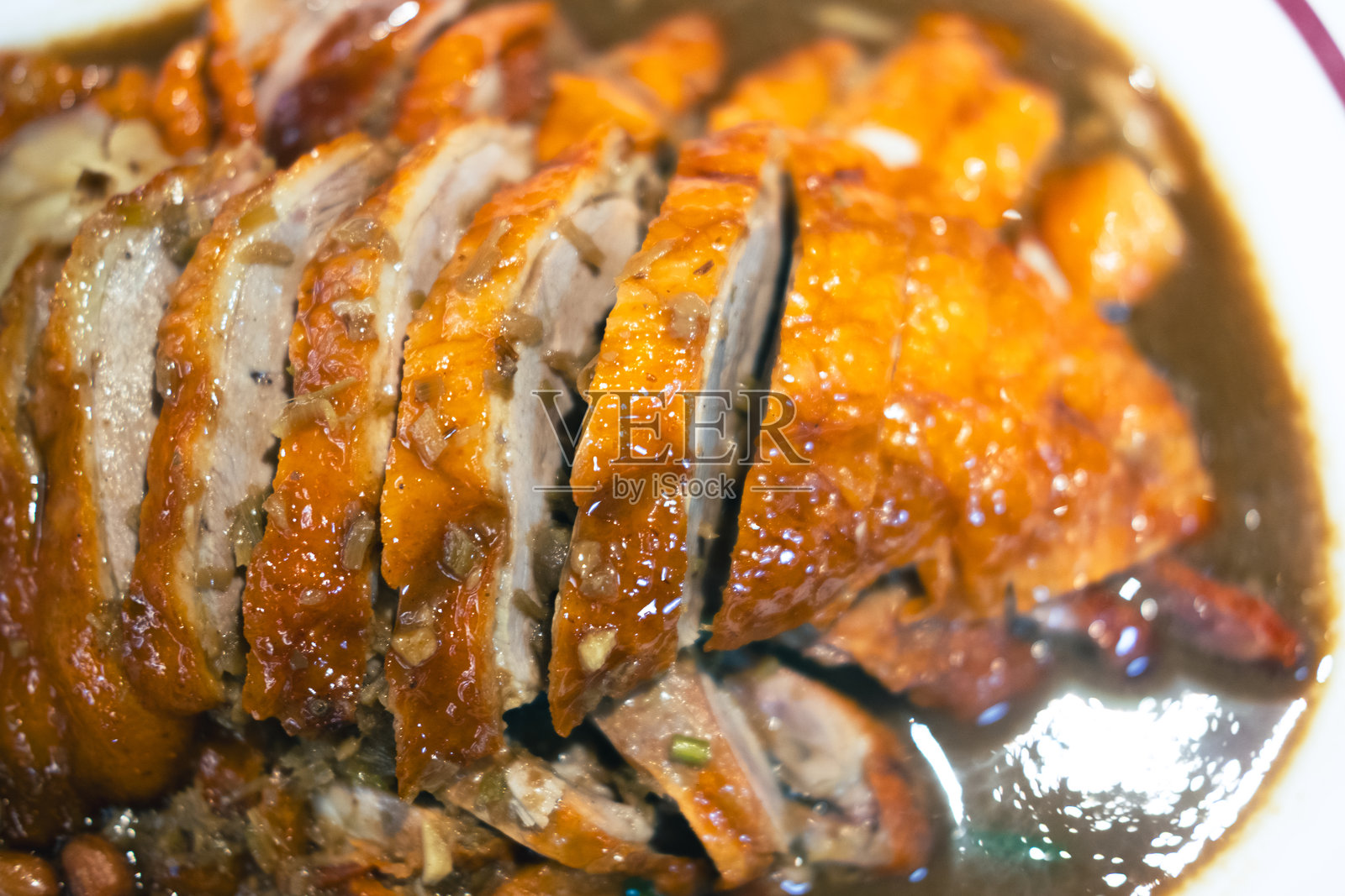 一盘切片的烤鸭,皮脆肉嫩。照片摄影图片