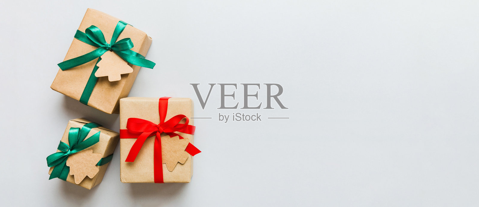 用彩色丝带包裹的圣诞或其他节日手工礼物,放在五彩缤纷的桌子上,礼物盒的装饰,俯视图,留有空白空间。照片摄影图片