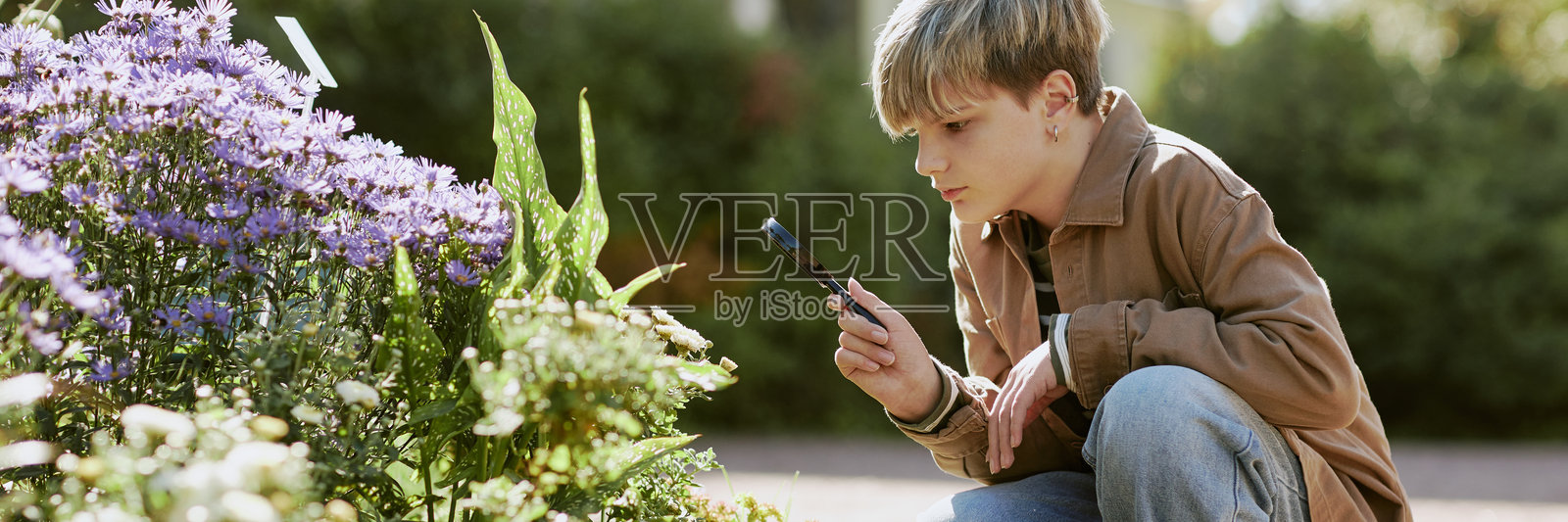 在植物园中使用放大镜的青少年照片摄影图片
