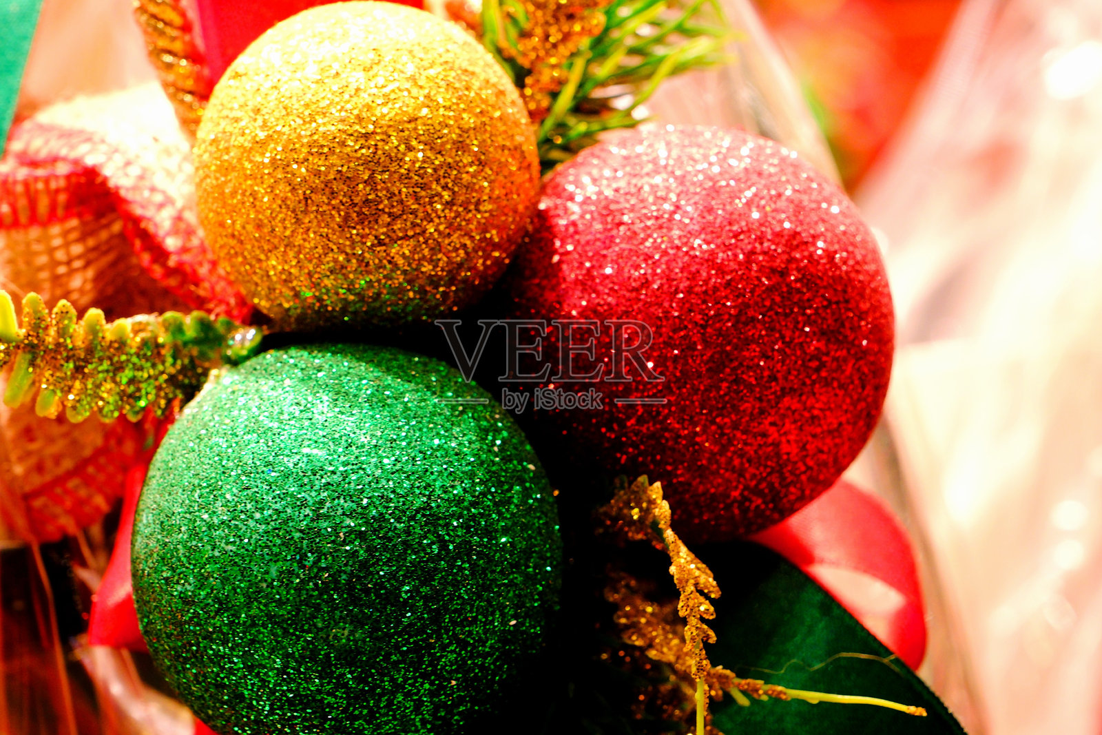 用红色、绿色和黄色镀金球体制作的圣诞礼物包装和装饰。照片摄影图片