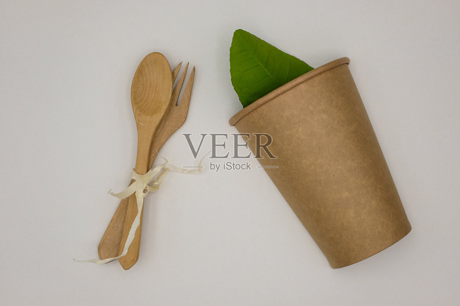 天然环保一次性餐具。杯子、勺子、叉子和木制吸管屑。照片摄影图片