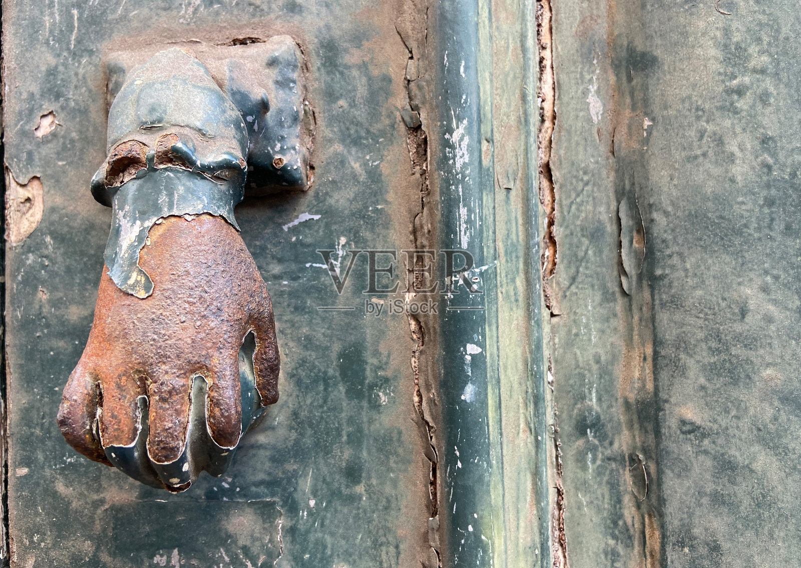 古老金属门把手,手形门环,背景是古老的木门。照片摄影图片