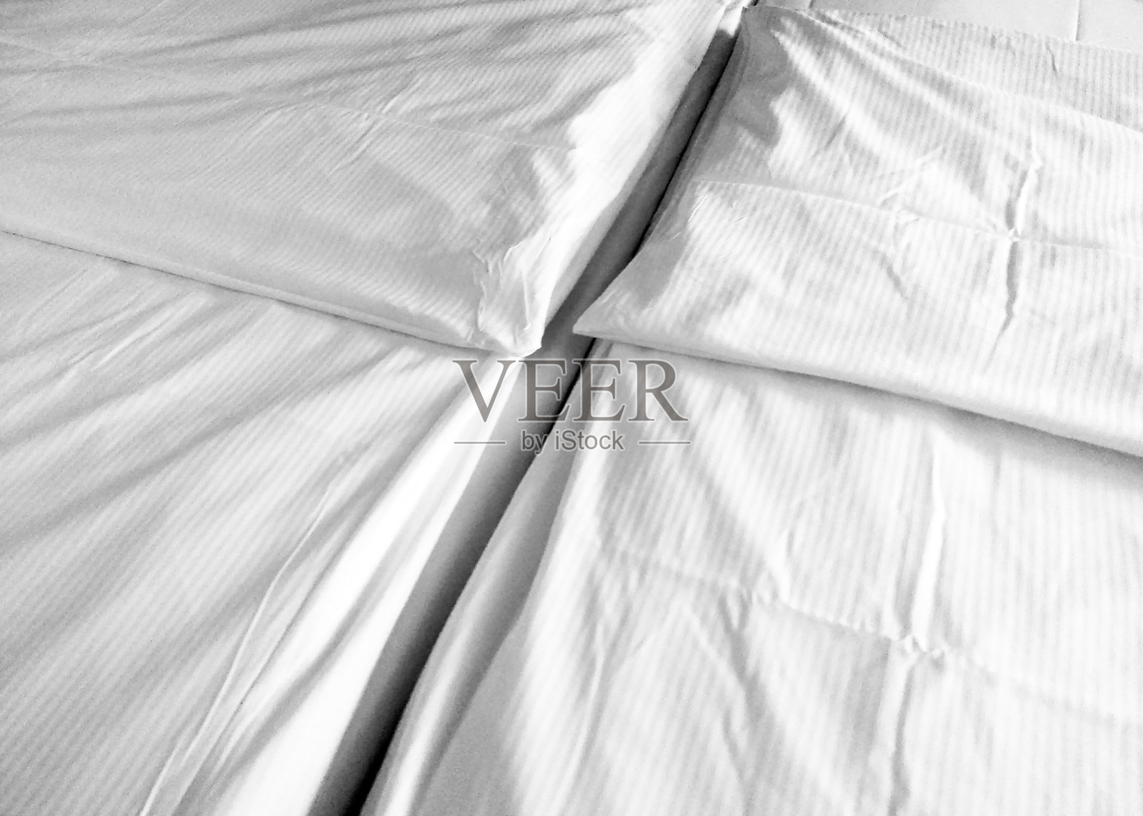 极简主义卧室设计,配有清爽的白色床上用品和干净的美学照片摄影图片