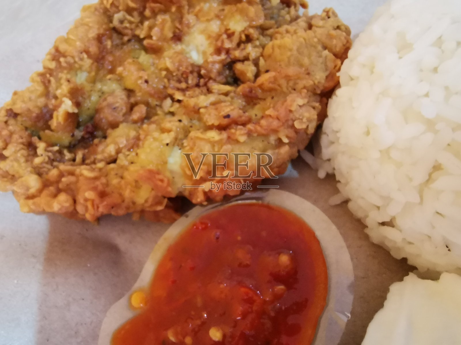 高角度视图的香辣 sambal 炸鸡(Ayam Geprek)盘子照片摄影图片