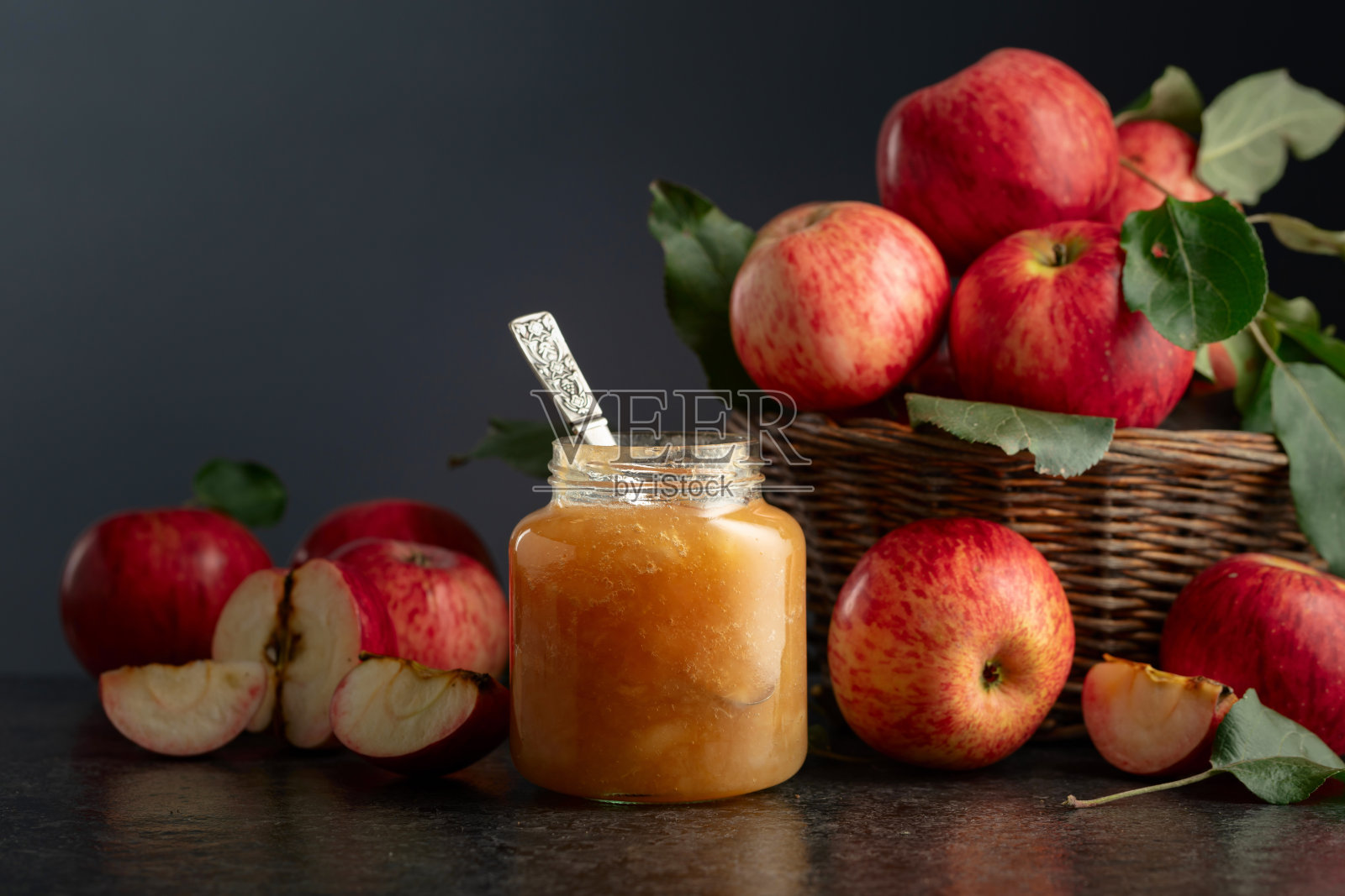 黑色石桌上的苹果果酱和新鲜苹果。照片摄影图片