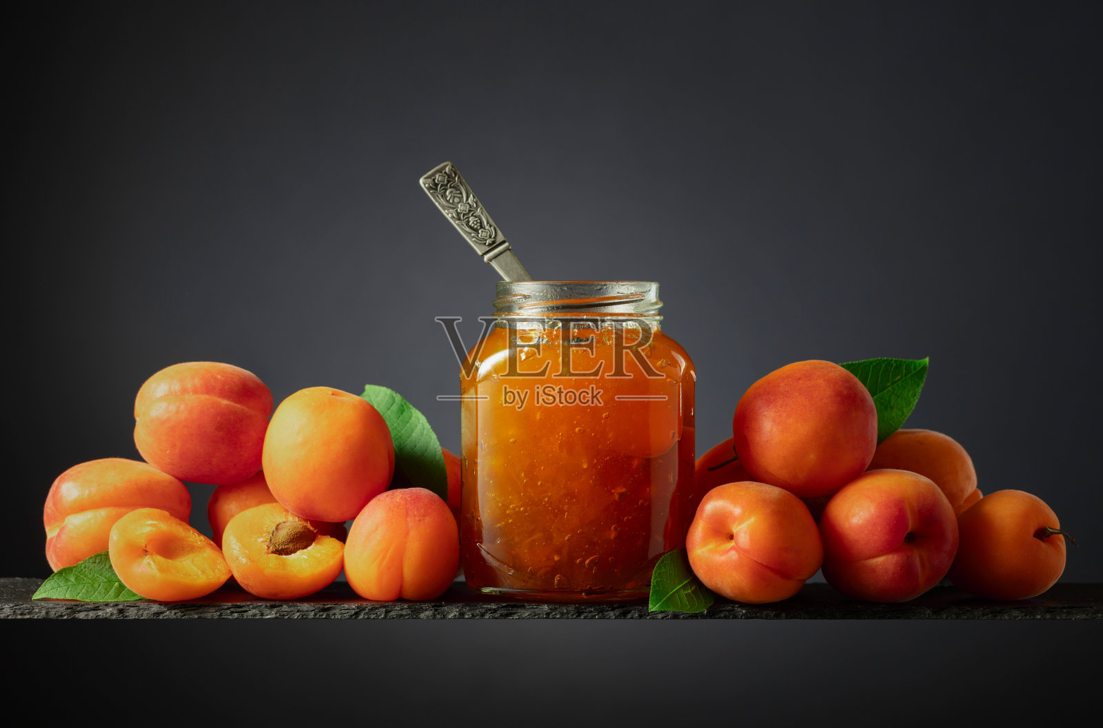 玻璃罐中的杏子果酱和新鲜水果。照片摄影图片