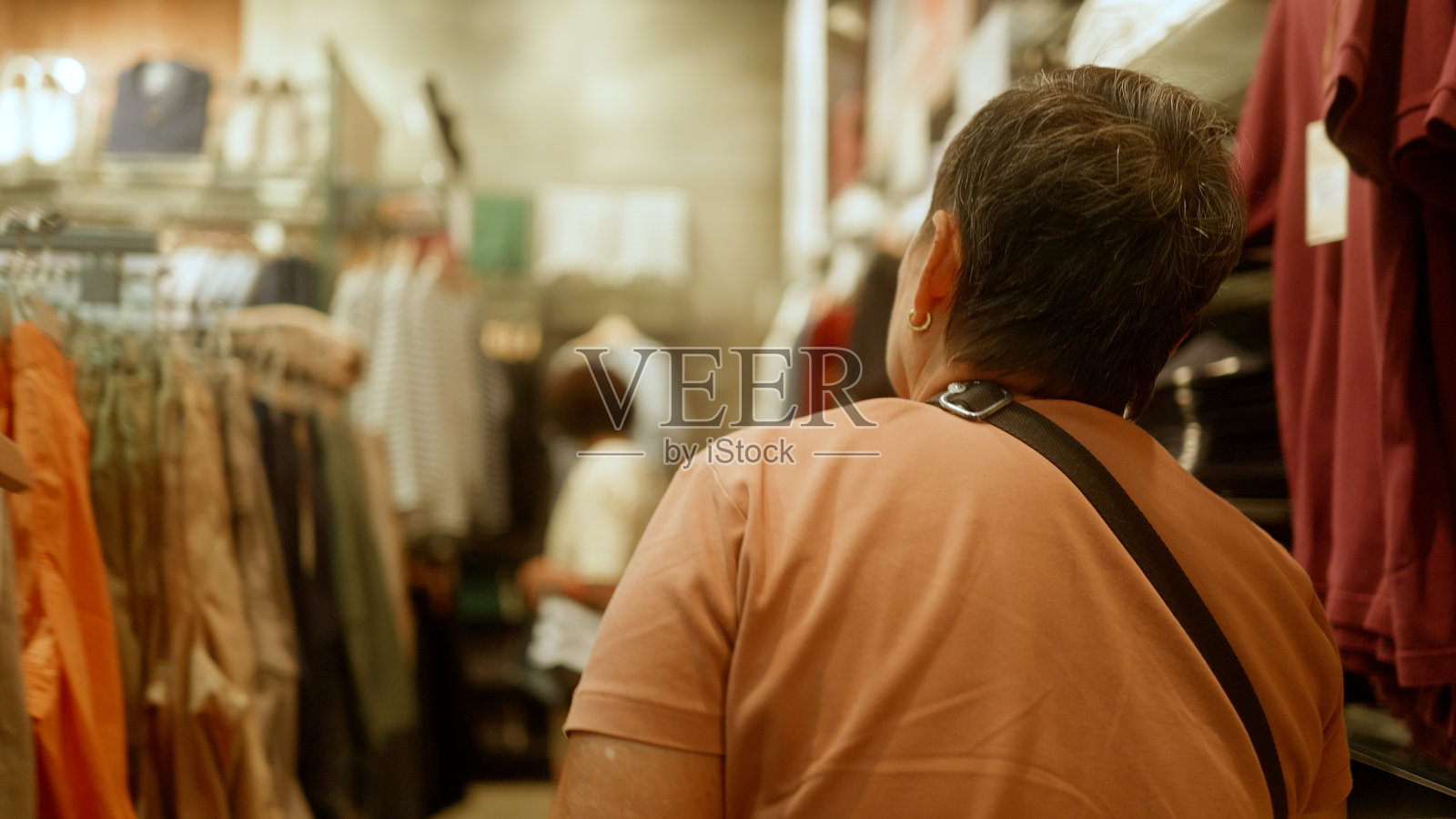 亚洲老年女性在购物并挑选衣服。照片摄影图片