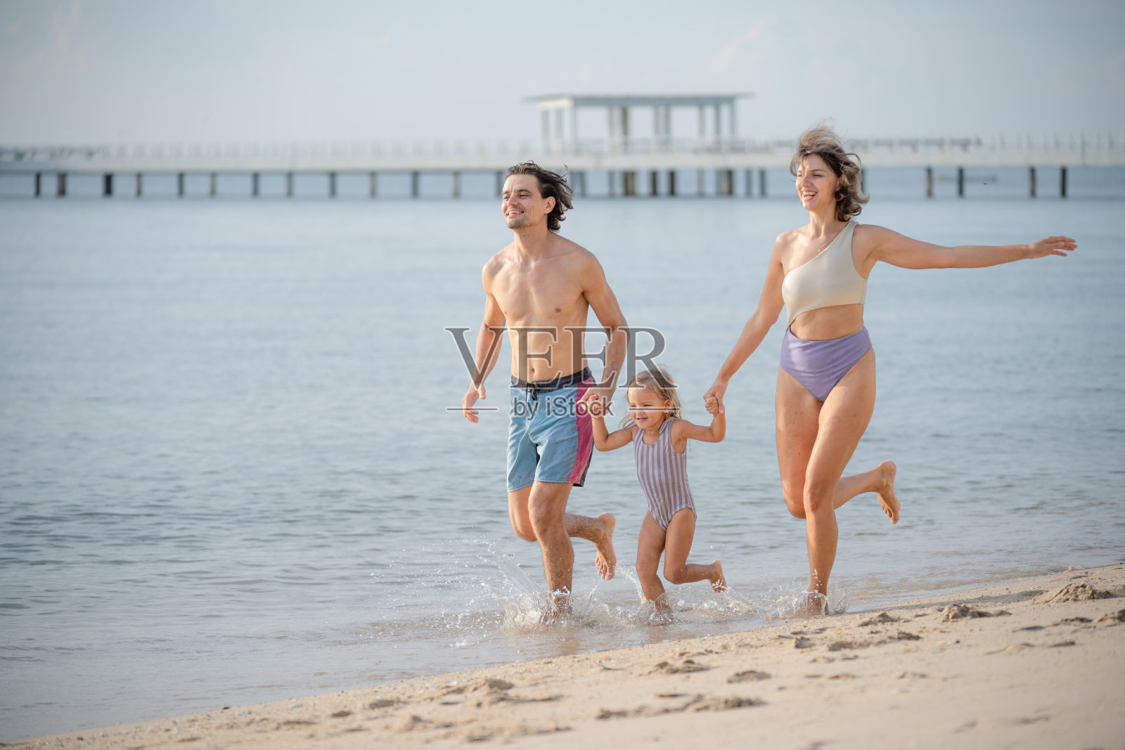 快乐的家庭假期在海滩上。照片摄影图片
