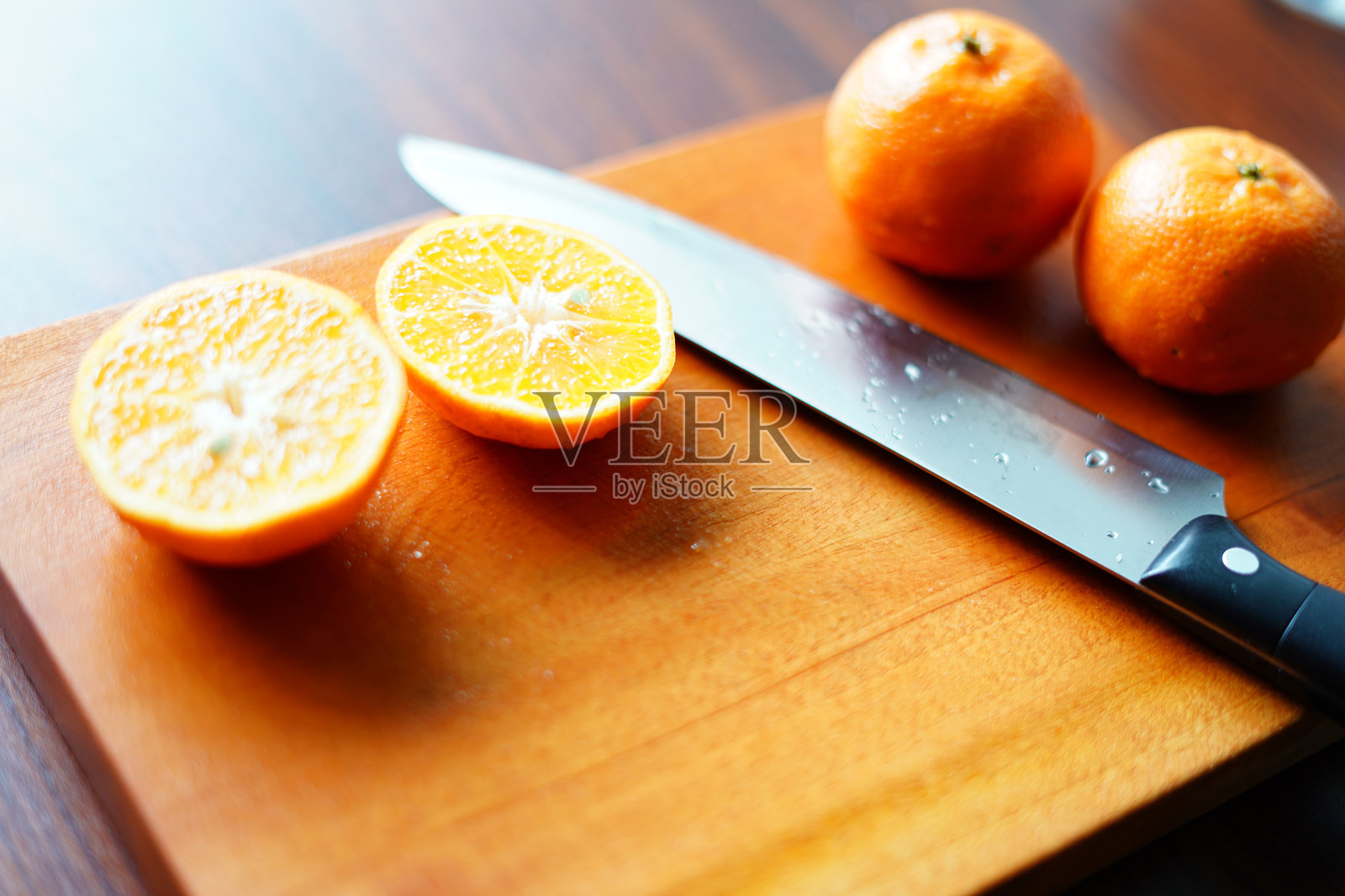在粗糙的木板上用刀切橙子。高质量照片照片摄影图片