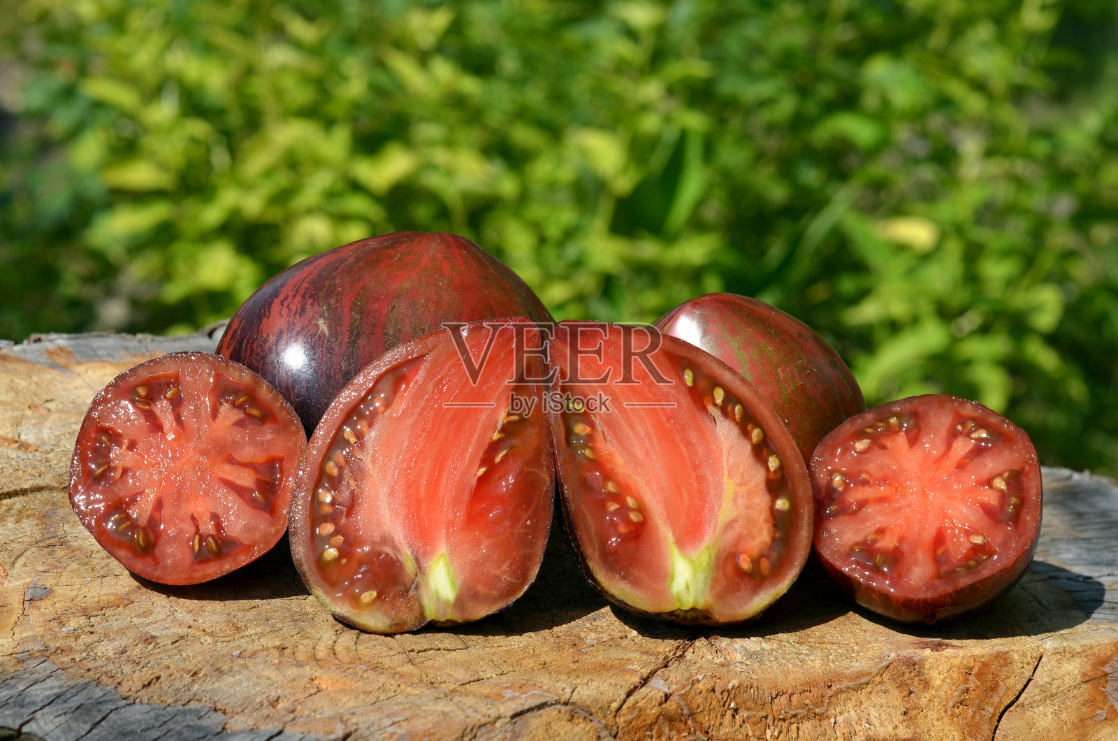 不寻常的红色条纹番茄,纵向和横向切开。照片摄影图片