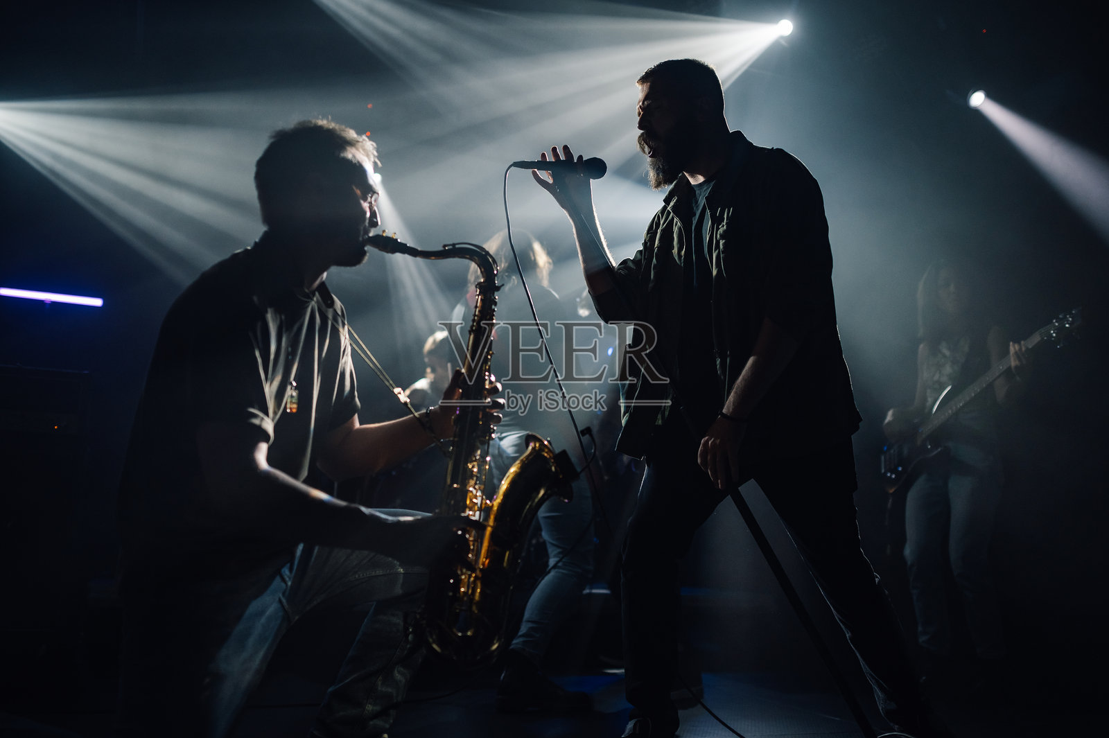乐队在舞台上现场演出,配有萨克斯风和麦克风照片摄影图片