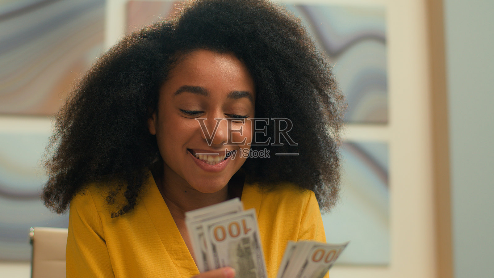 快乐的非裔美国女商人,富有成功的女企业家,正在办公室里数着现金,微笑着计算工资和财务。照片摄影图片