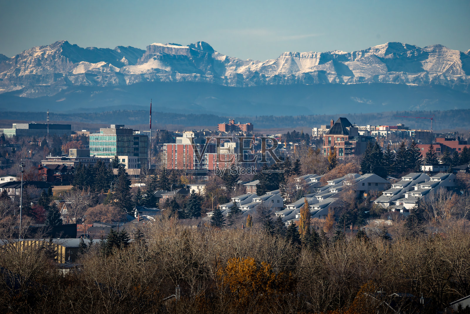 卡尔加里,阿尔伯塔省,加拿大的城市天际线,公寓楼和高层建筑俯瞰加拿大落基山脉。照片摄影图片
