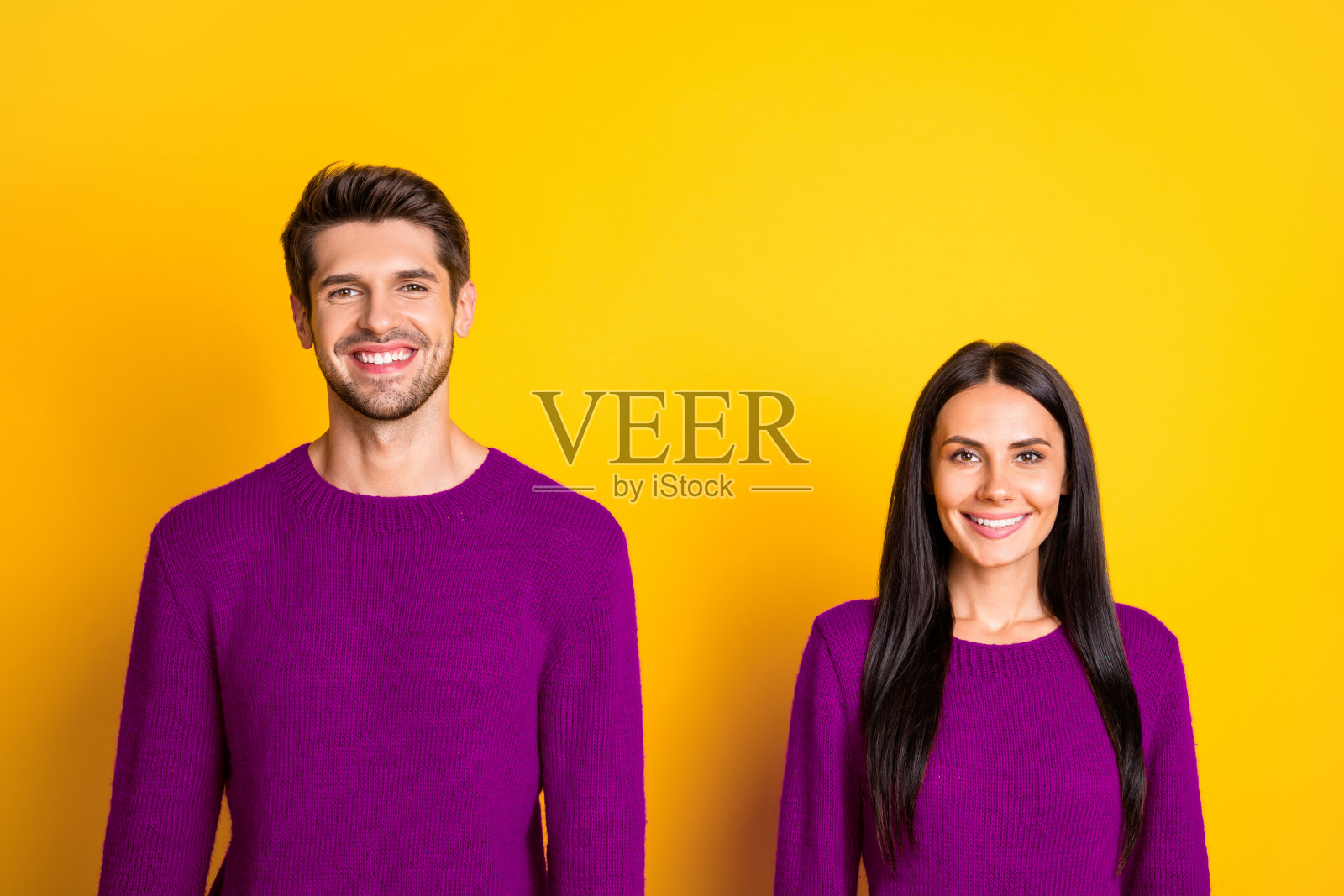 迷人的男女肖像,微笑着穿着红色毛衣,背景为黄色。照片摄影图片