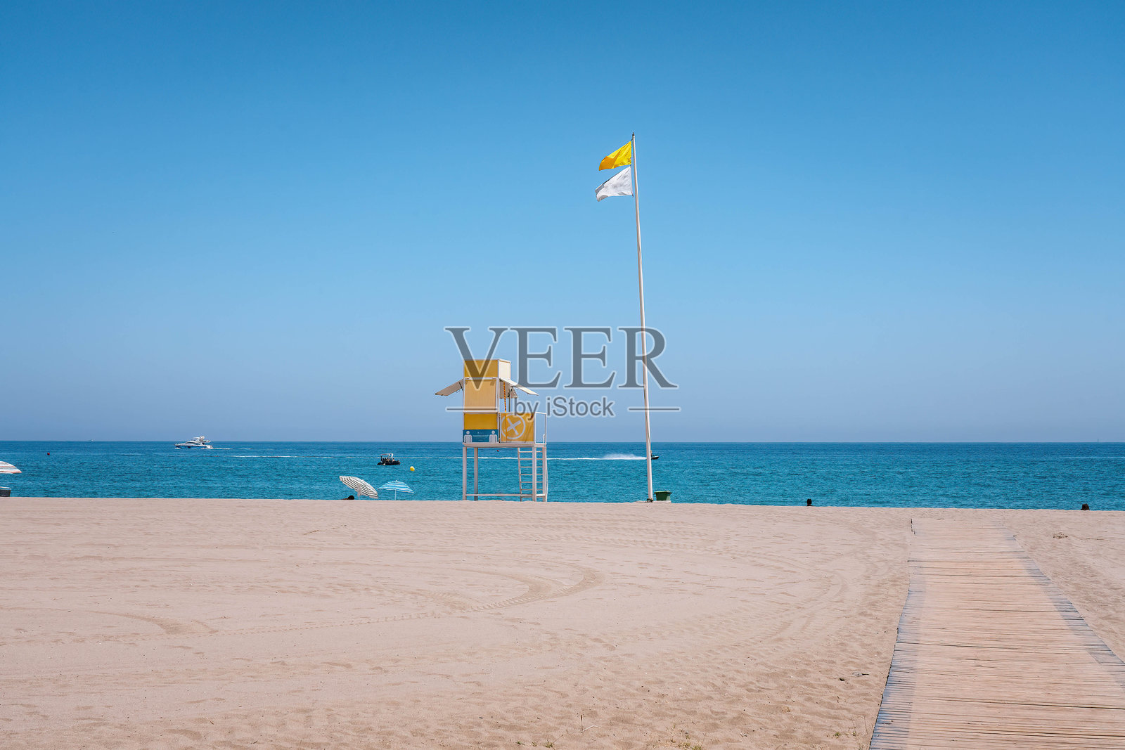 阳光明媚的夏日,空旷海滩上的救生塔。照片摄影图片