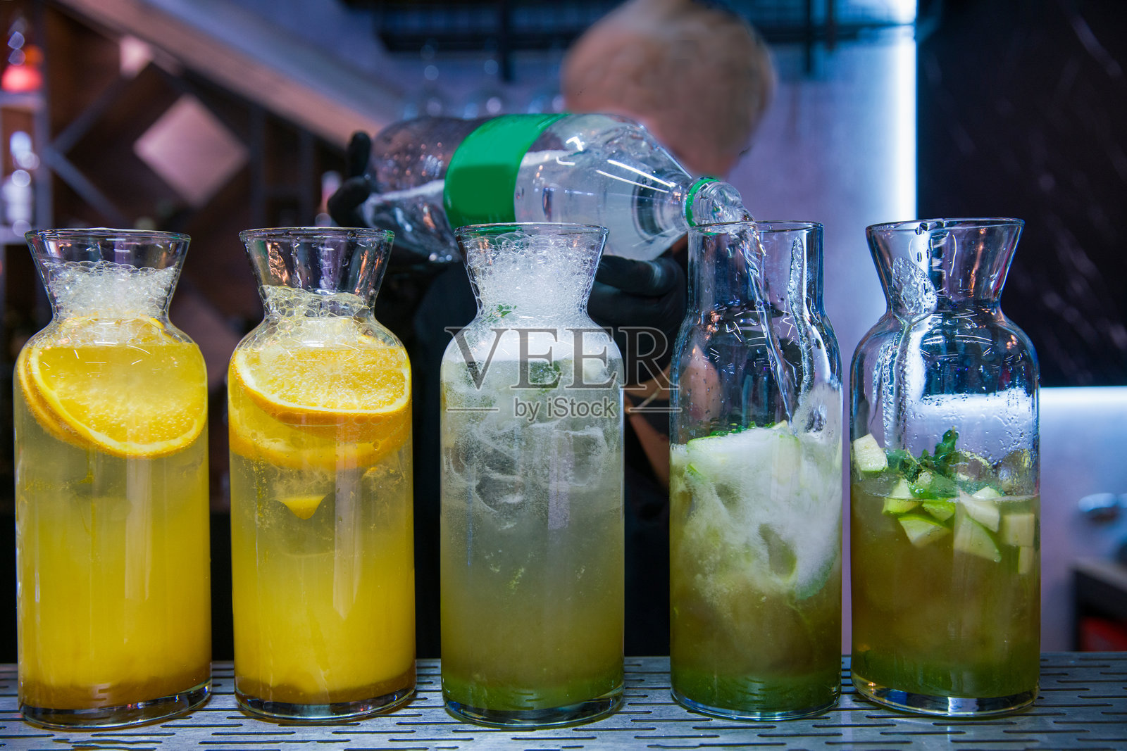 无糖柠檬水和鸡尾酒。远处的调酒师 - 不可辨认的人。照片摄影图片