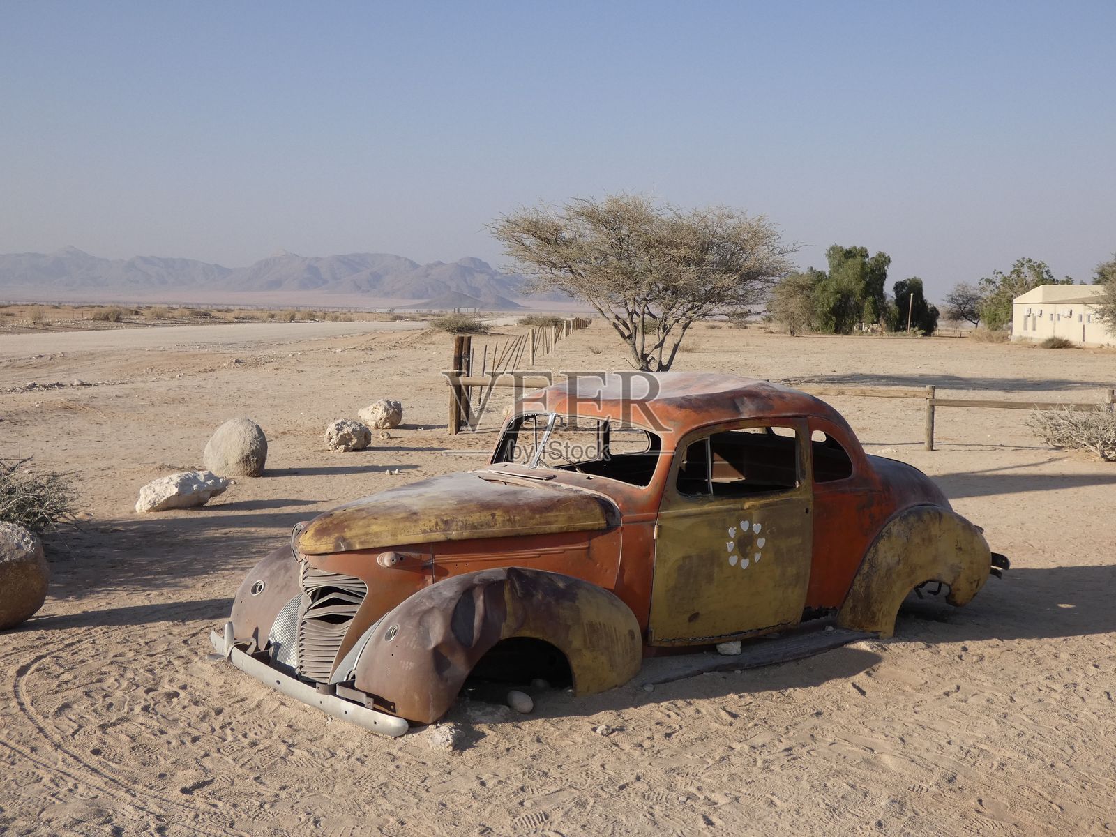 废弃的复古汽车在沙漠景观中。照片摄影图片
