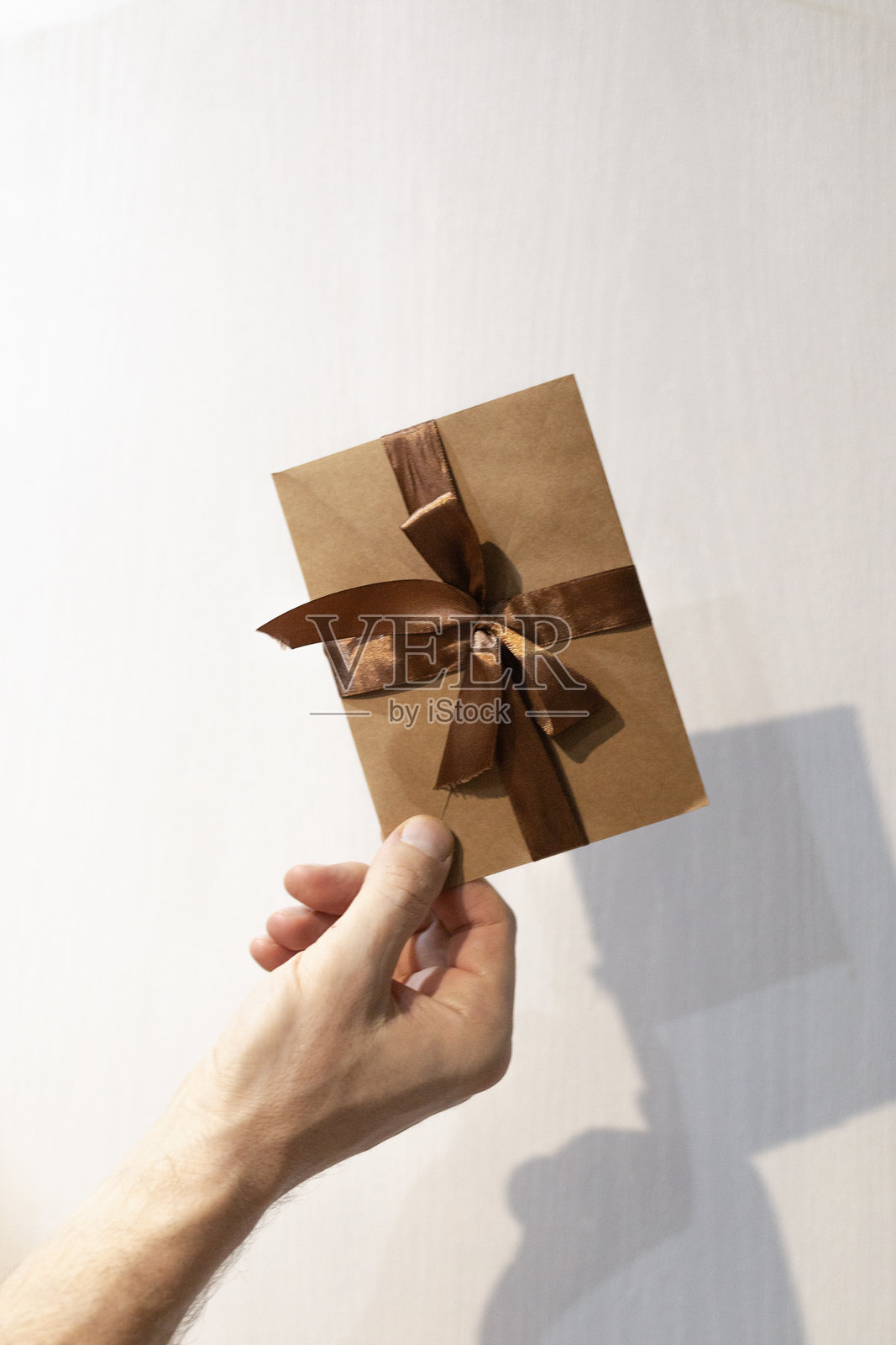 男性手持棕色证书,配有棕色缎带,礼品券,代金券照片摄影图片