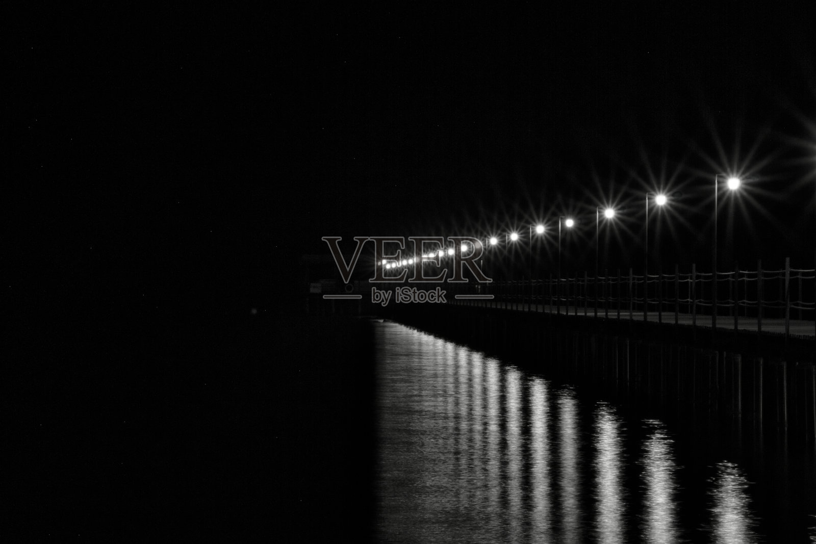 夜间拍摄的灯笼照亮的码头伸入红海。埃及马萨阿拉姆照片摄影图片