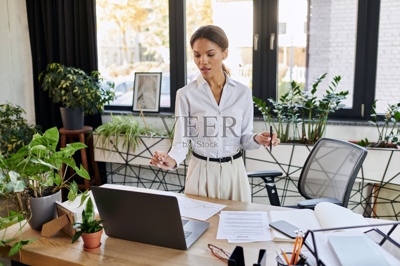 年轻女商人在充满活力的办公室环境中专注于高效工作照片摄影图片