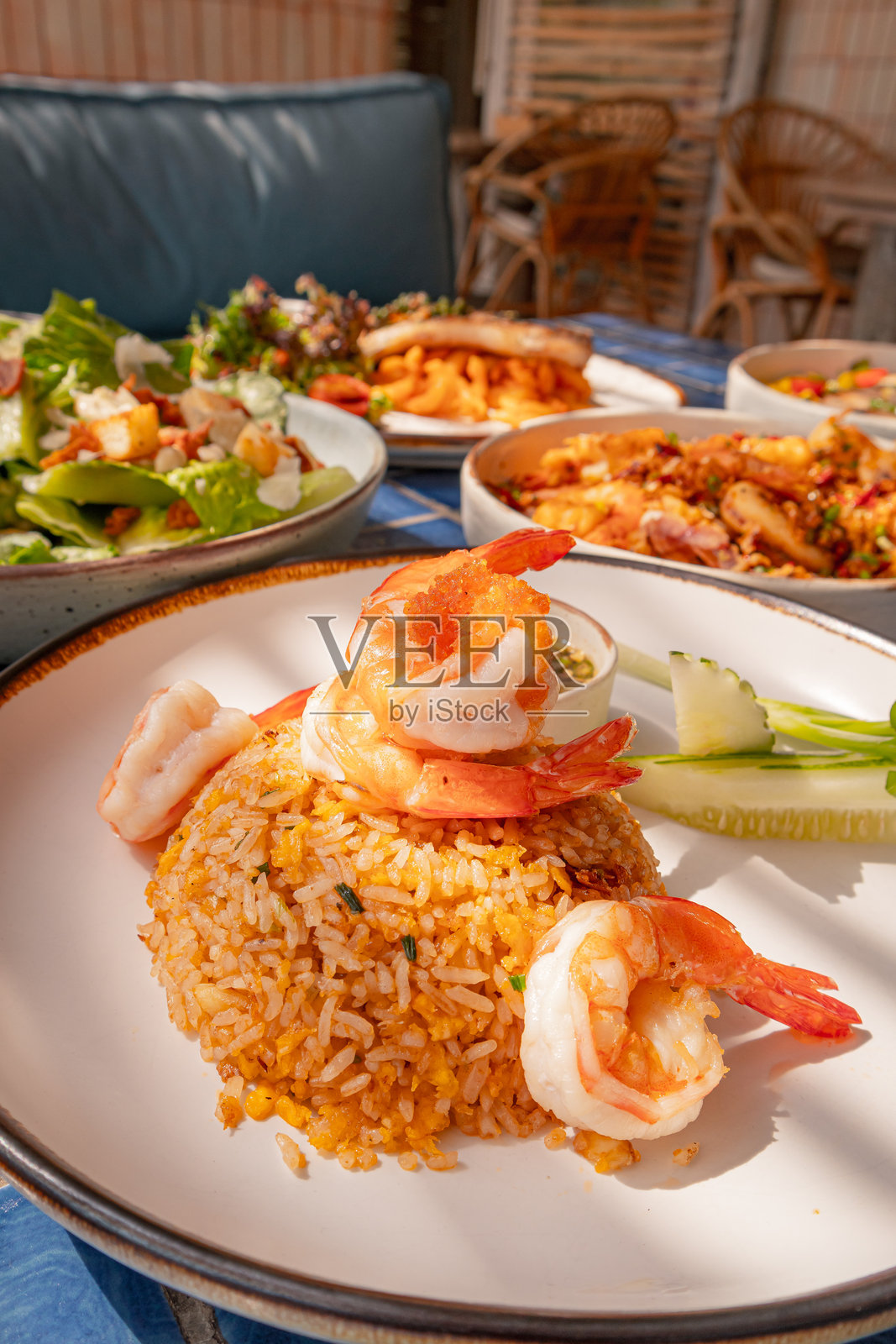 特写,蓝色瓷砖表面上的虾仁炒饭和一杯鱼露,泰国菜照片摄影图片