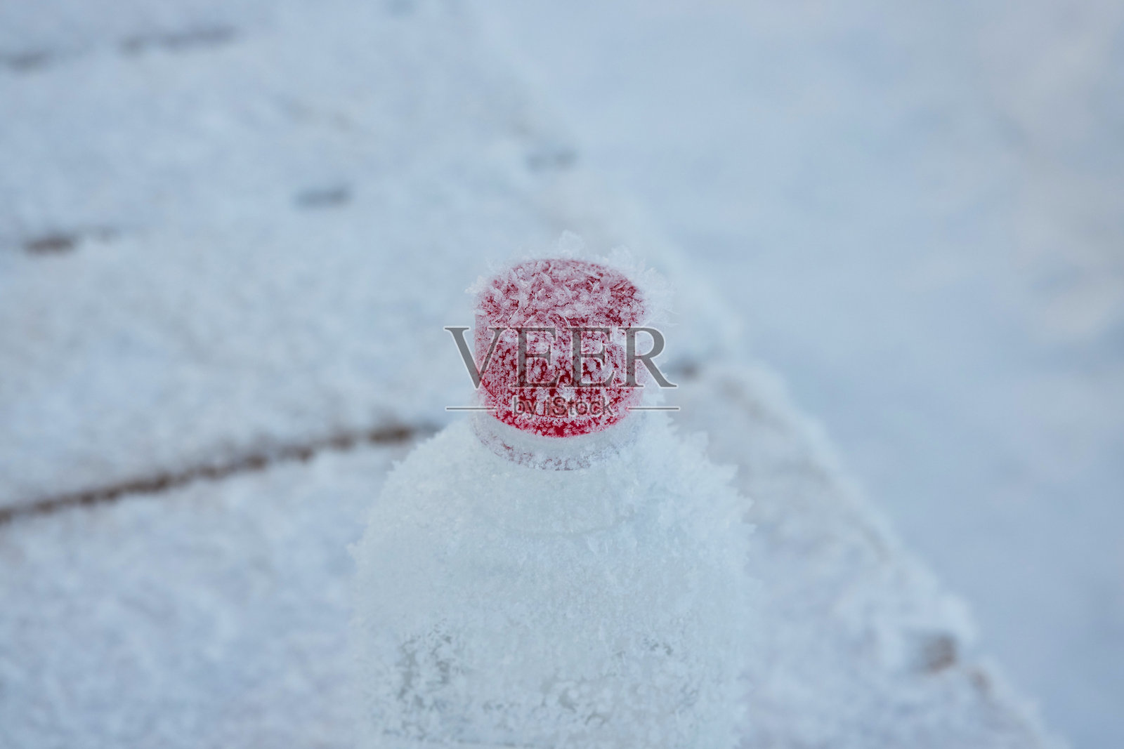 一个带有冰晶的霜冻水瓶放在寒冷的霜冻表面环境中照片摄影图片