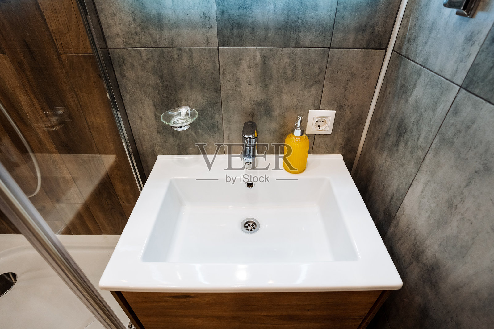 洗手间的洗手池显眼地位于中央,台面上方便地放置着一个肥皂分配器,提升了这个温馨空间的功能性和美观性。照片摄影图片