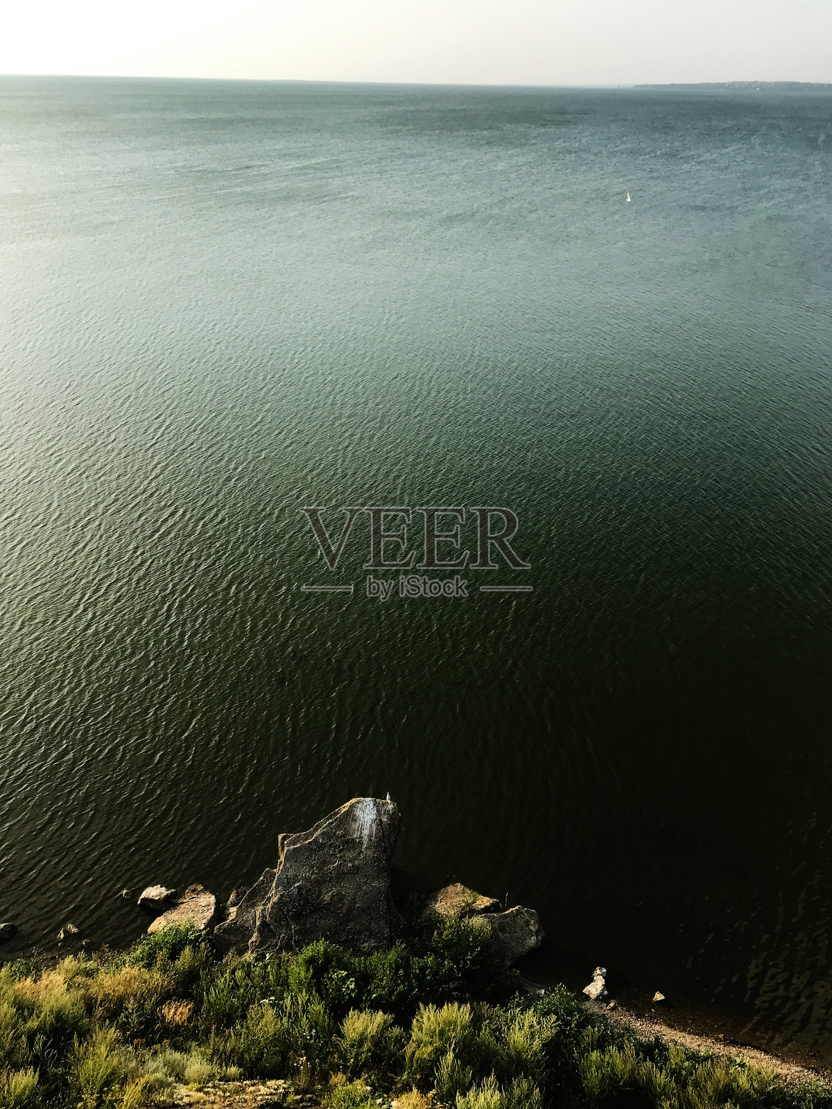 宁静的湖边景色,岩石海岸和广阔的水面照片摄影图片