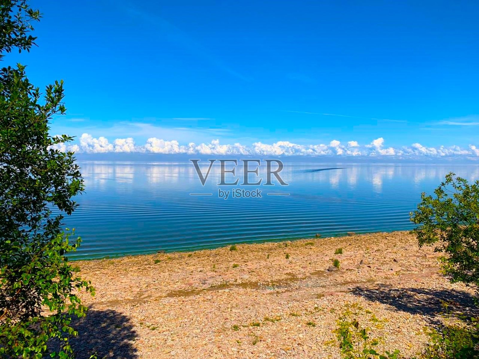 从悬崖俯瞰湖泊,延伸至地平线。照片摄影图片