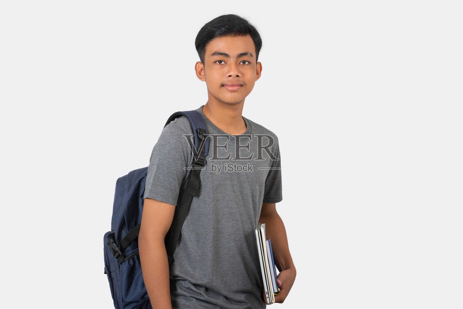 微笑的年轻大学生,手持笔记本和背包,准备上学,背景为白色。照片摄影图片