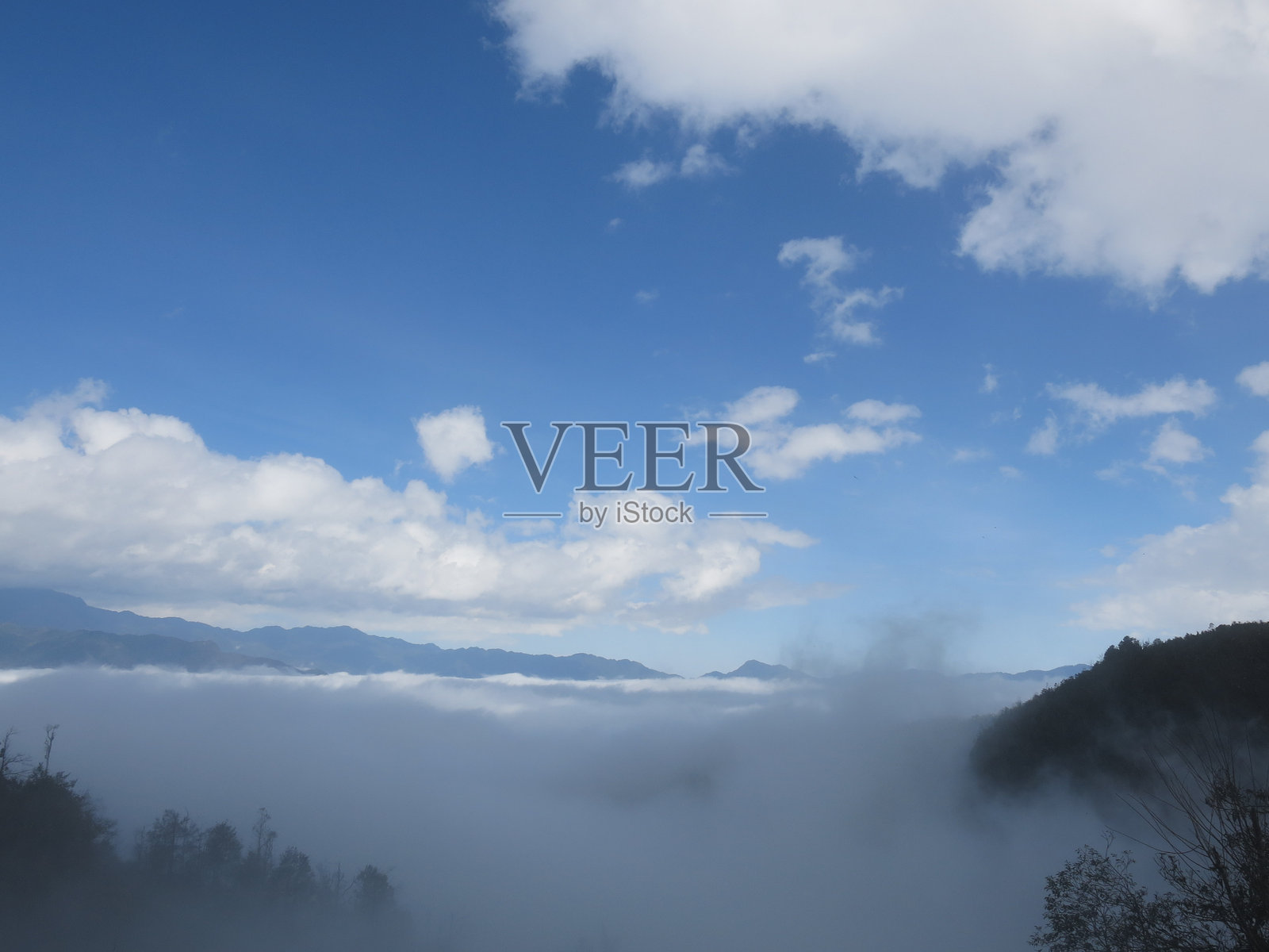 云朵和天空,蓝天上飘着小云朵,远处是山丘。全景照片摄影图片