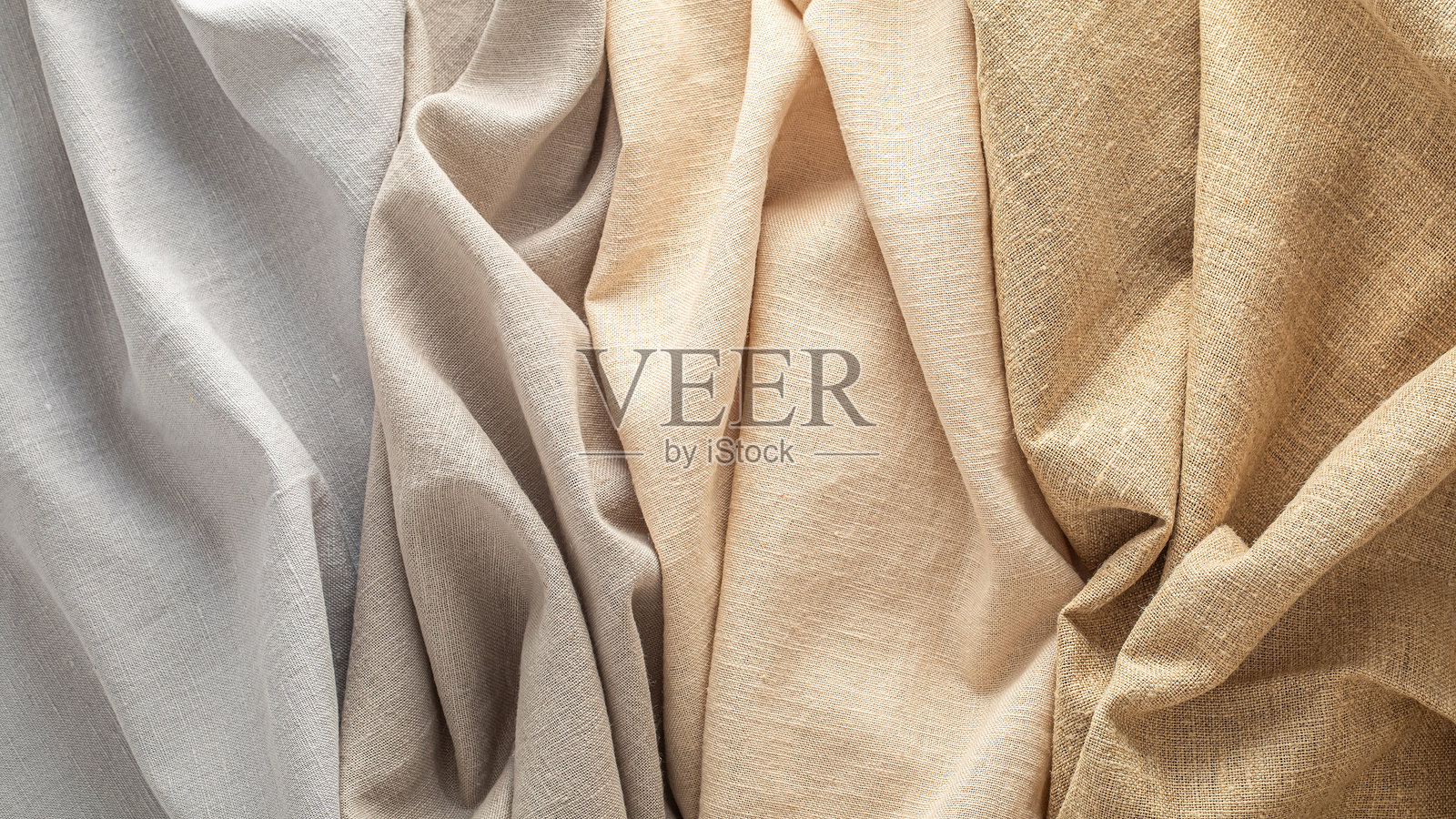 柔和色调的纺织品以褶皱的形式展示其质地和颜色照片摄影图片