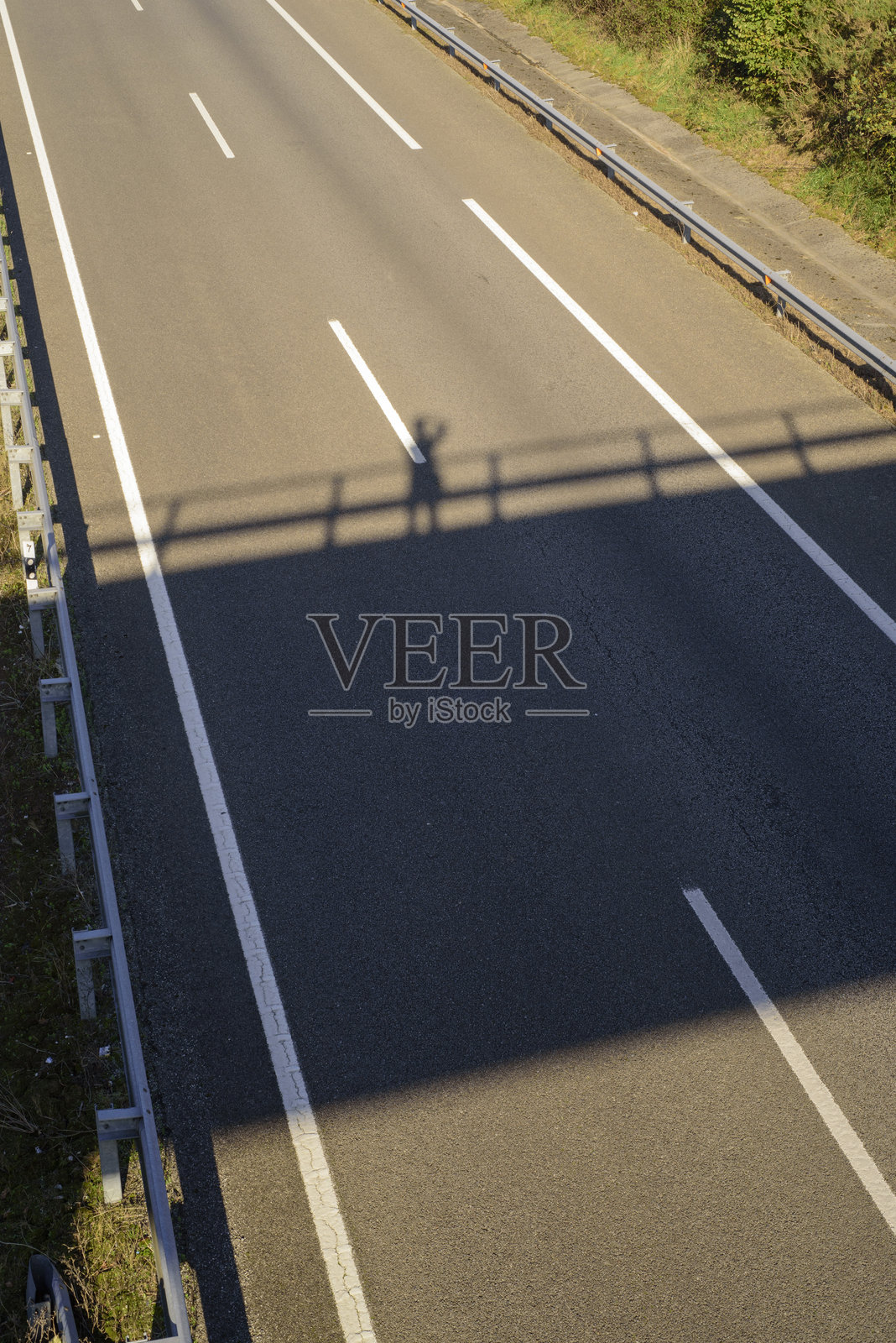 桥上摄影师的影子投射在道路上照片摄影图片